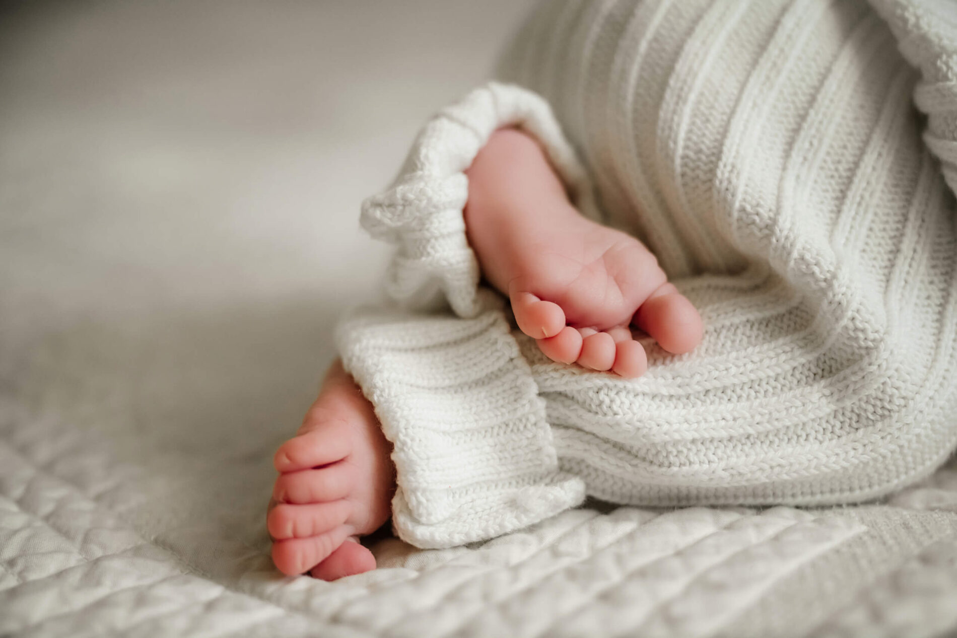 Close up on baby's feet during newborn photo session at home