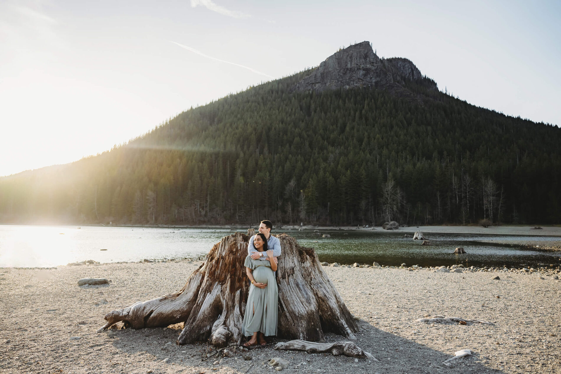 Happy couple smiling during a winter maternity photo shoot in the Cascade mountains