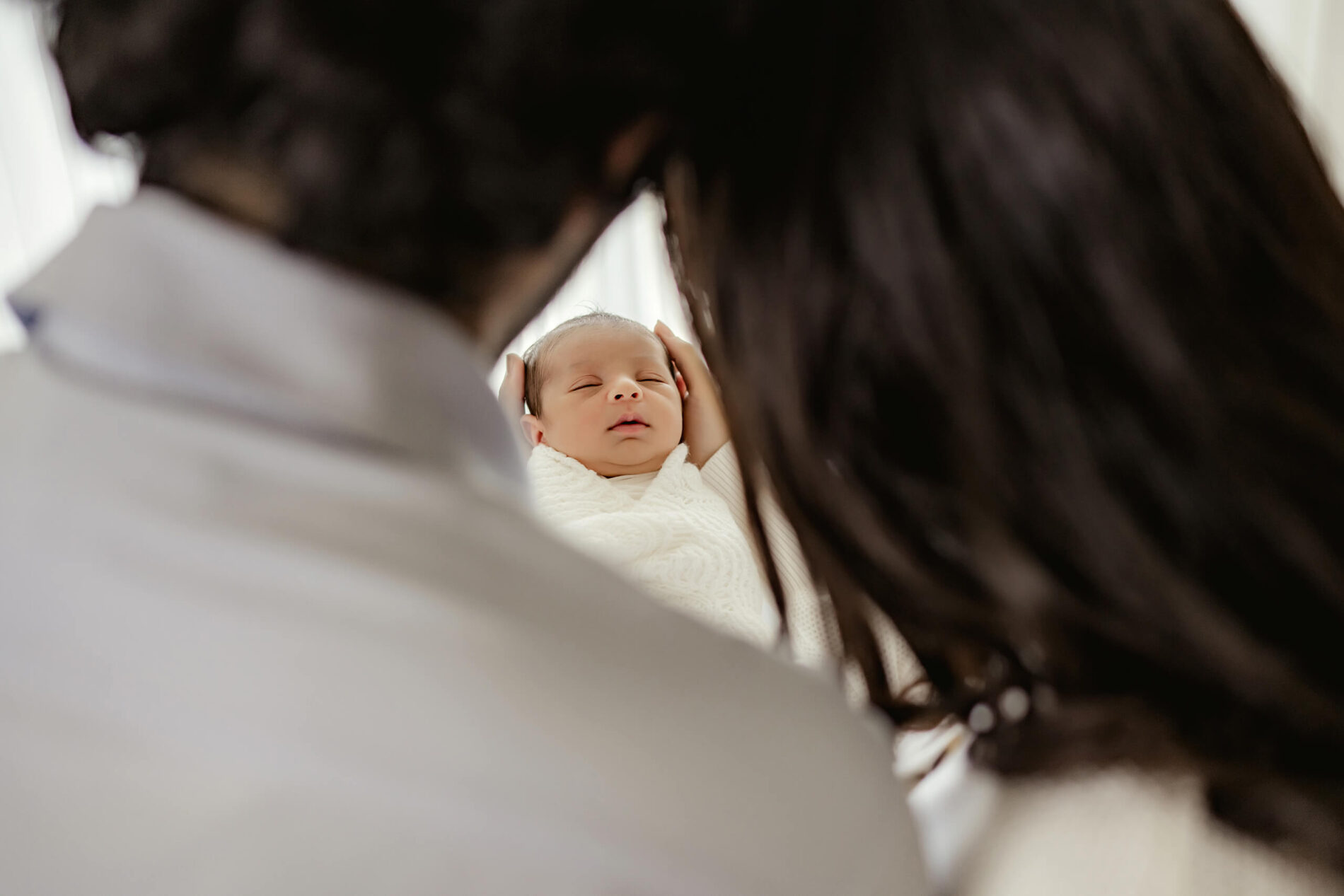 Unique newborn photography with parents, mom and dad holding baby boy