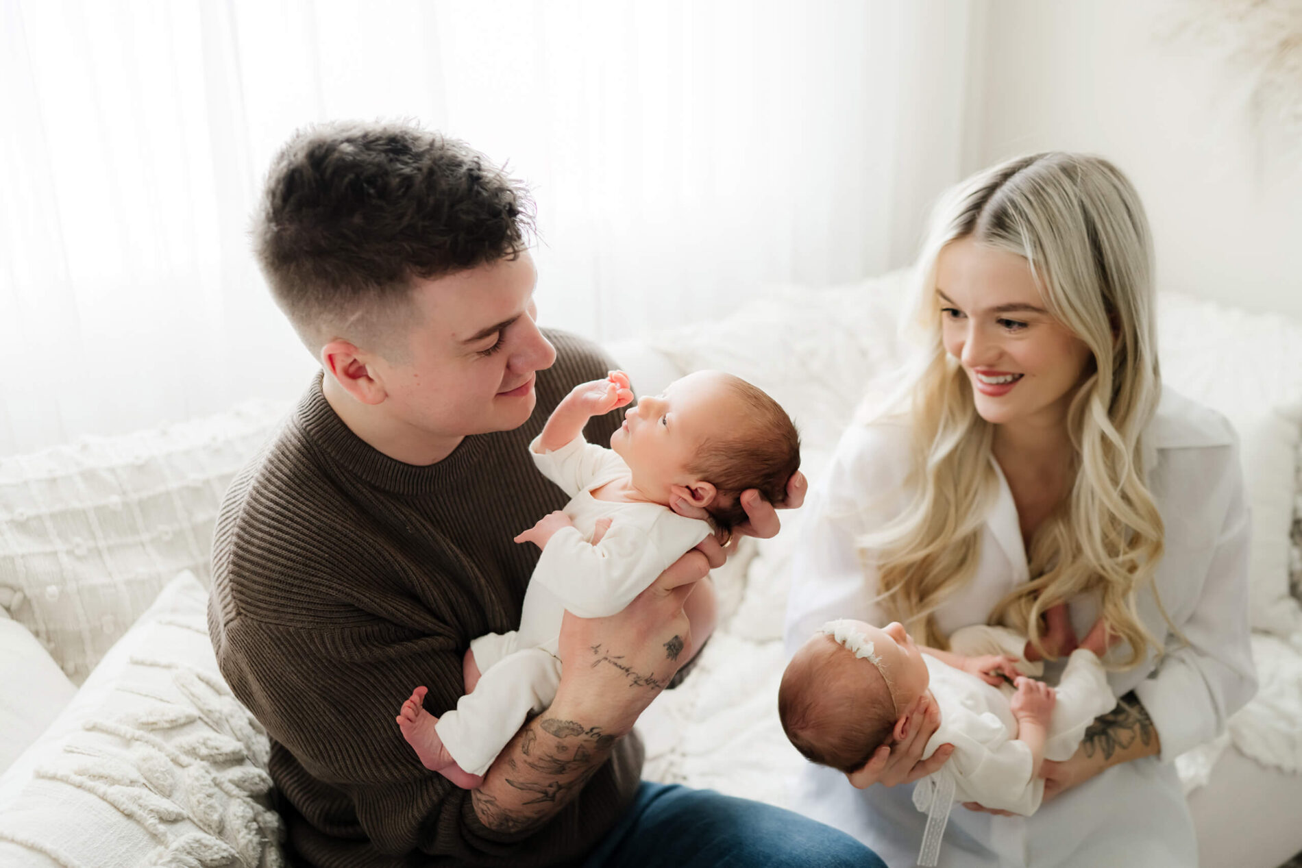 Newborn twin photography, dad playing with his son, mom smiling and playing with her daughter