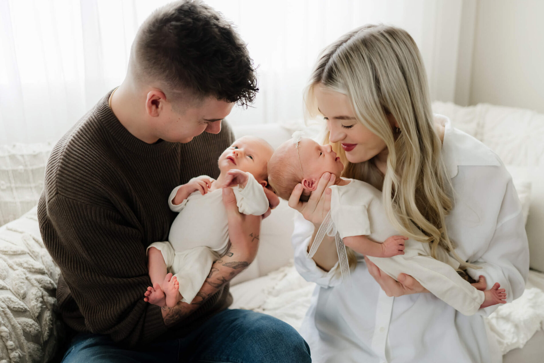 Newborn twin photography with parents, mom and dad posed naturally with their twins