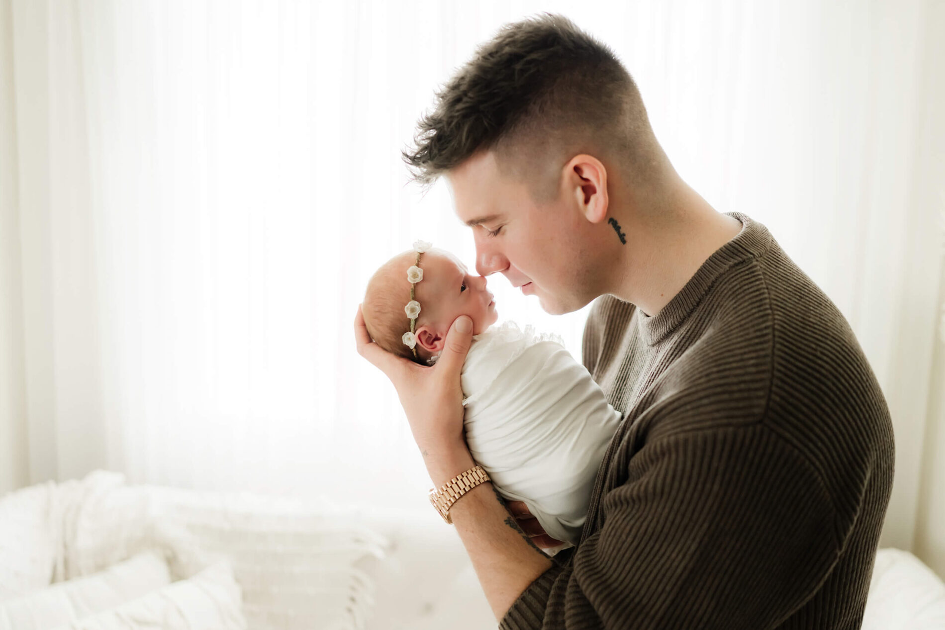 Newborn photography with dad holding his baby girl close to his face