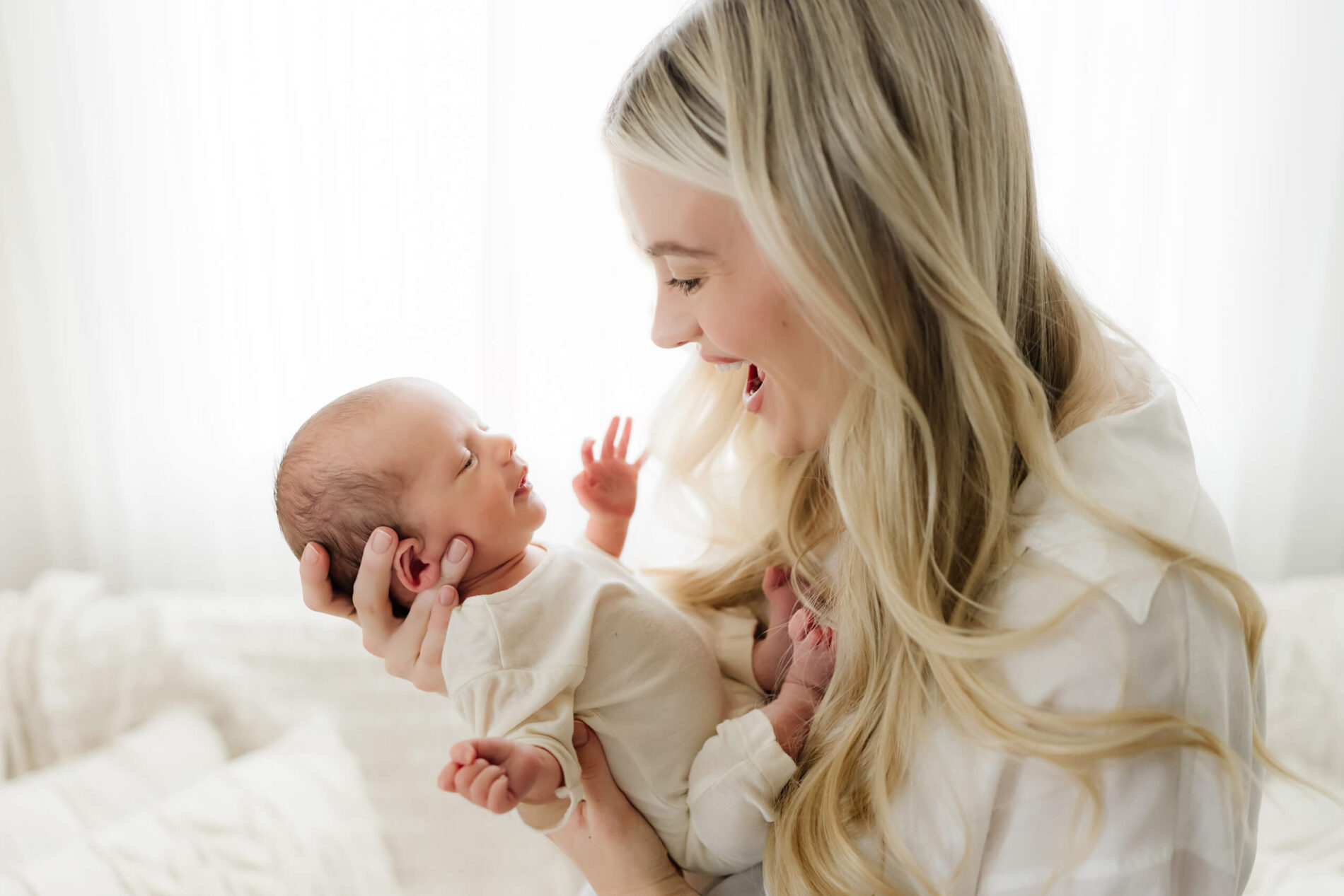 Moment during newborn photo shoot, mom playing with her baby boy