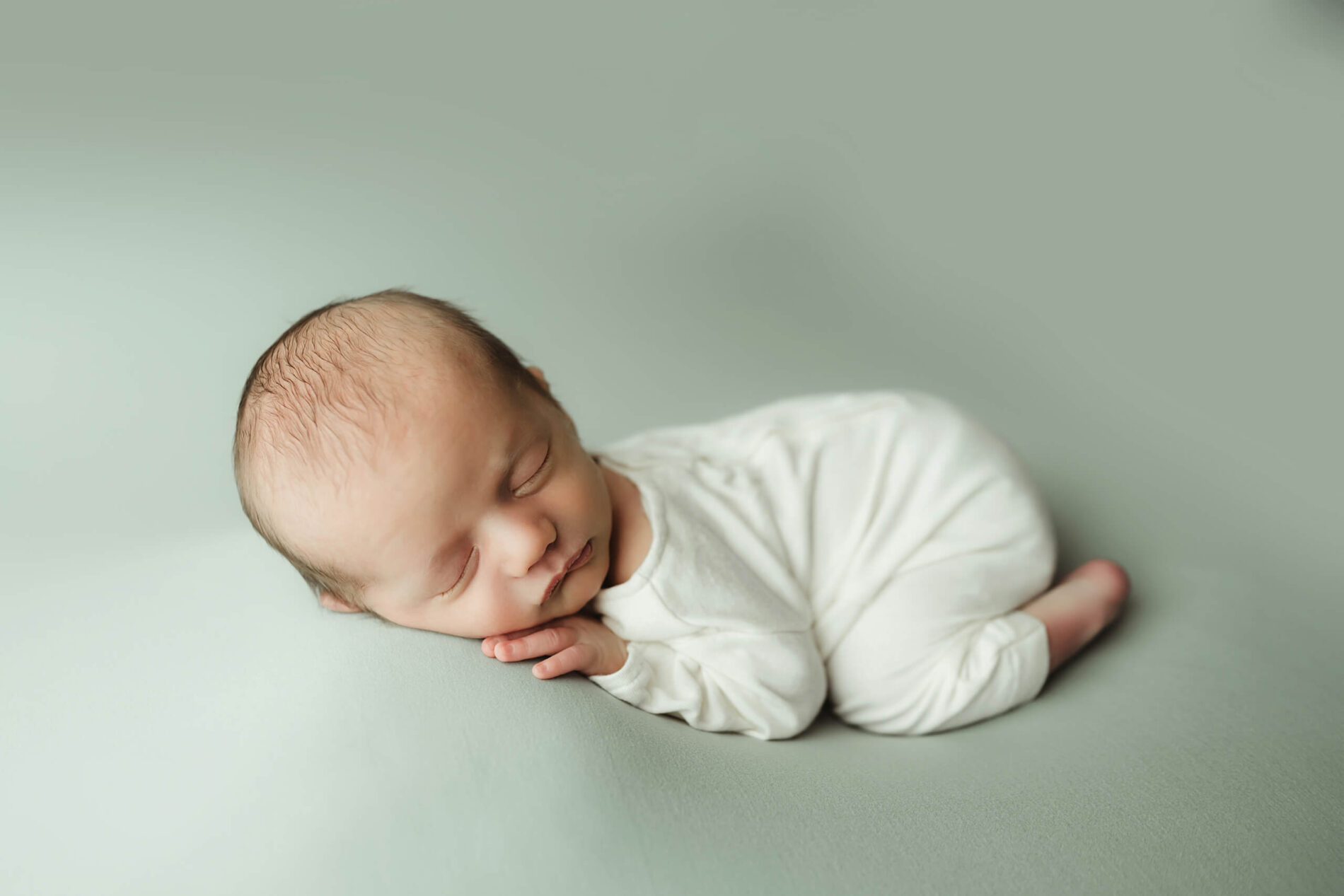 Newborn photography, sleeping baby boy in white onesie