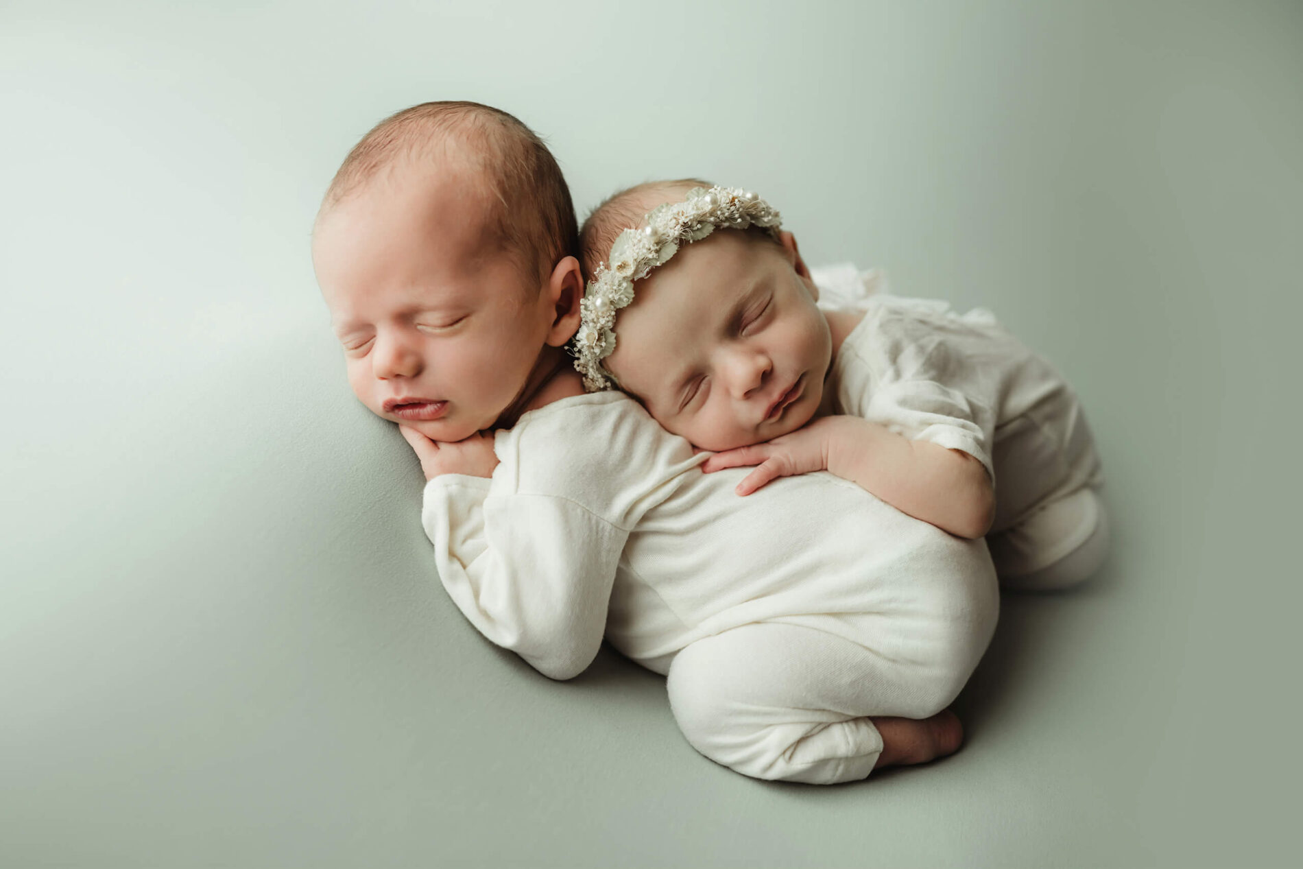 Twin newborn photography, sleeping brother with sleeping sister resting on his back
