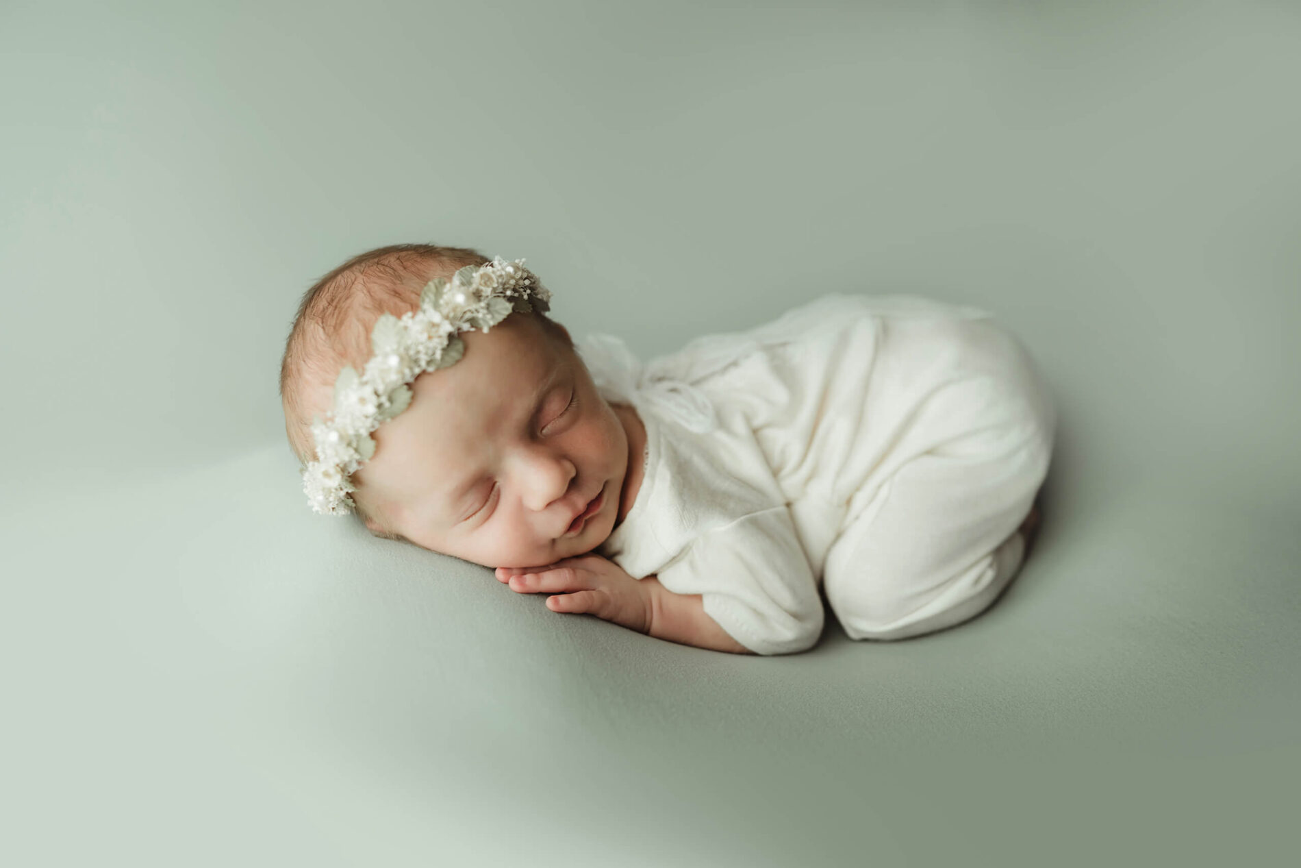 Newborn photography, sleeping baby girl wearing a floral headband