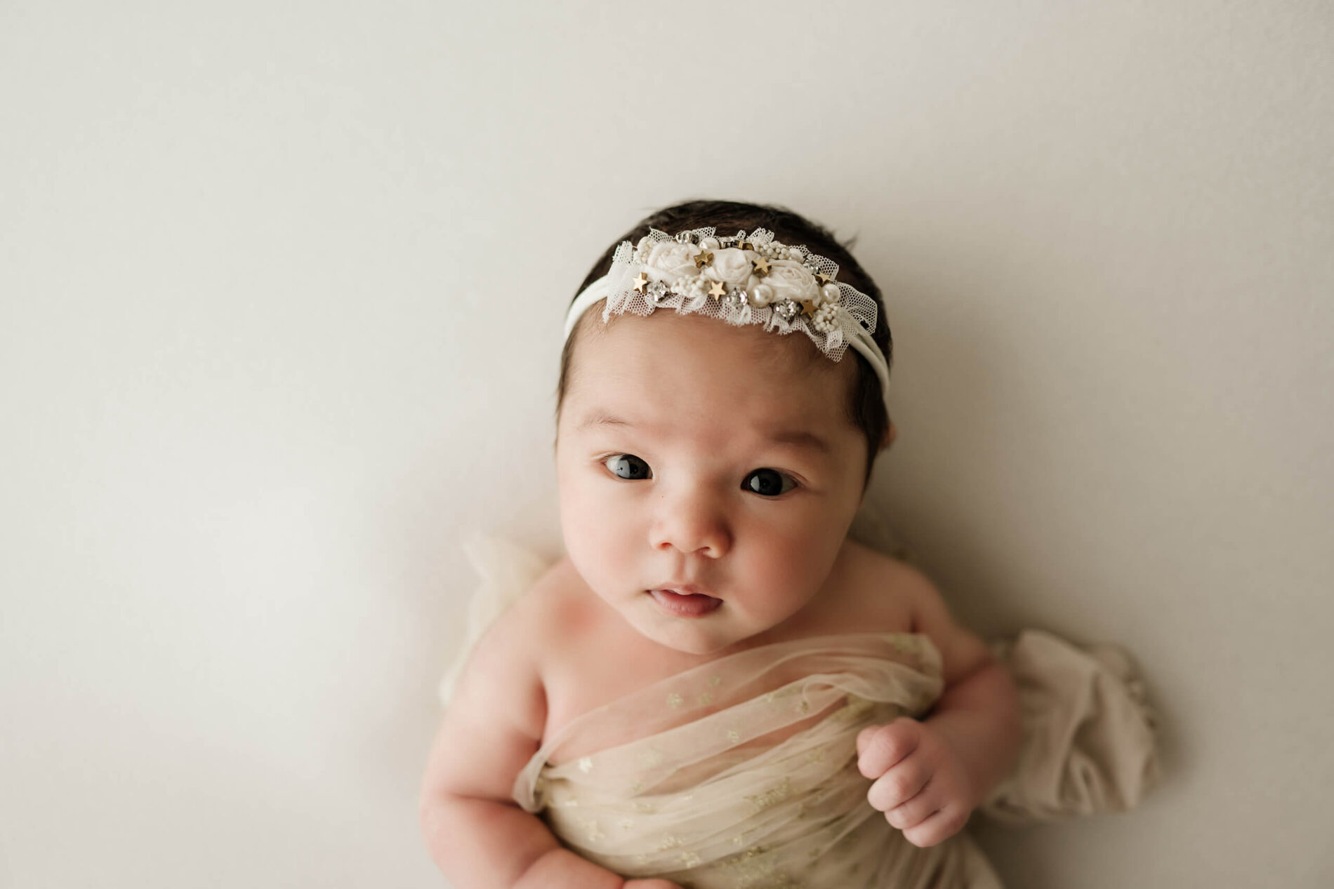 Focus on a the face of a beautiful baby girl during a newborn photo session