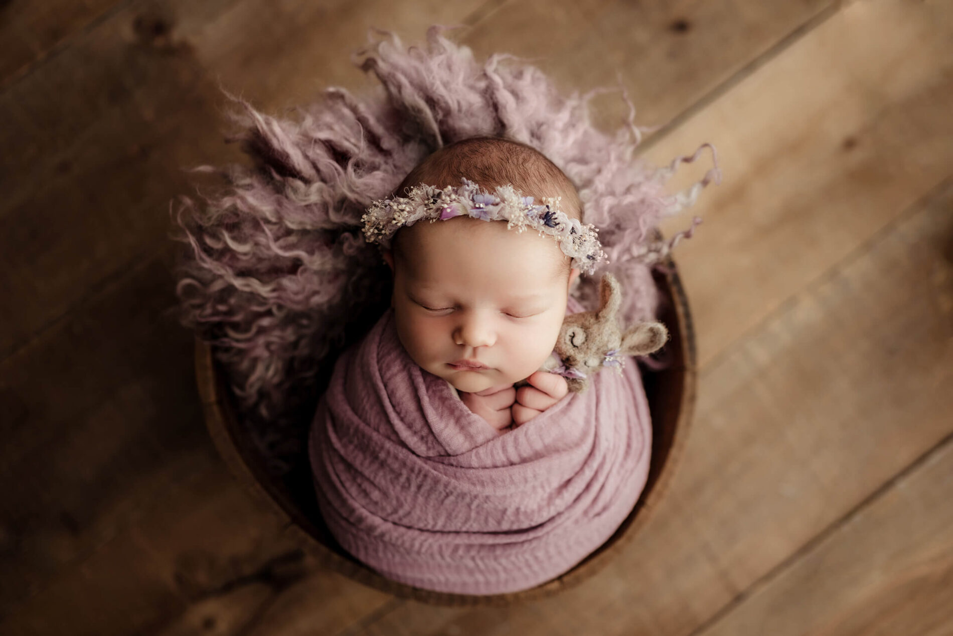 Baby girl posed in a basket during newborn photo shoot in Seattle