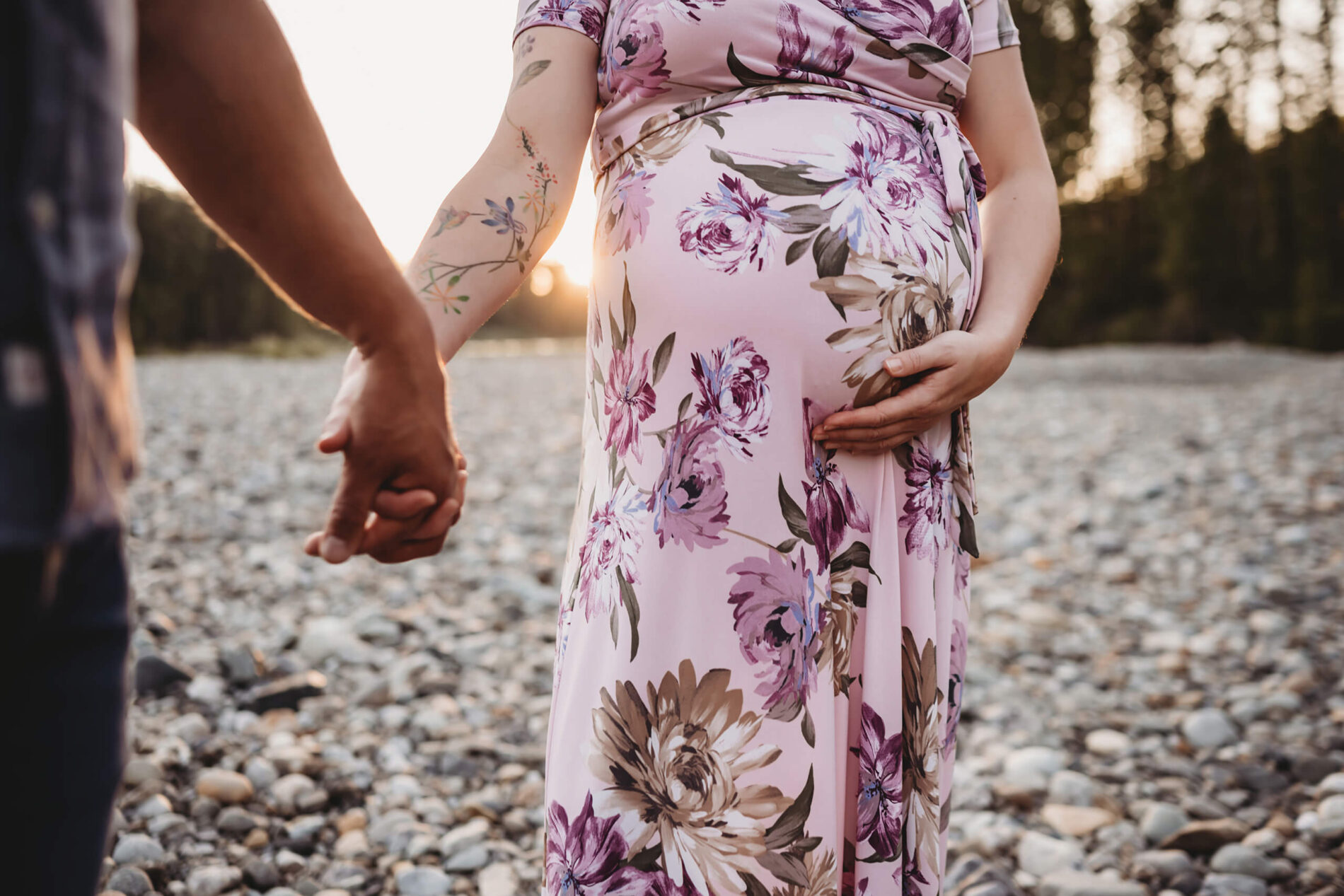 Outdoor maternity photo shoot in Seattle, focus on a couple holding hands