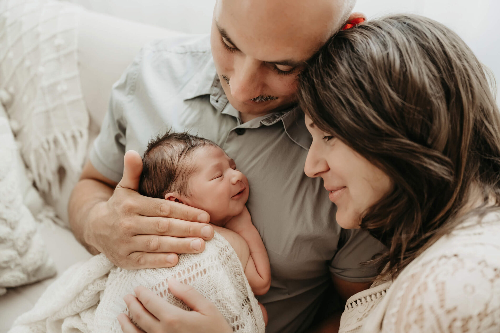 Parents cuddling with their baby son during newborn photo shoot in Seattle