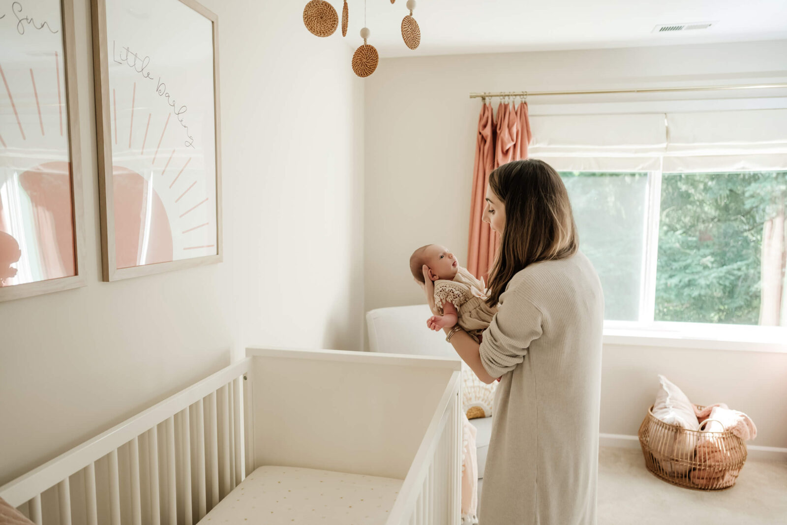 Mom holding her newborn in the nursery during a calm in-home newborn photo session