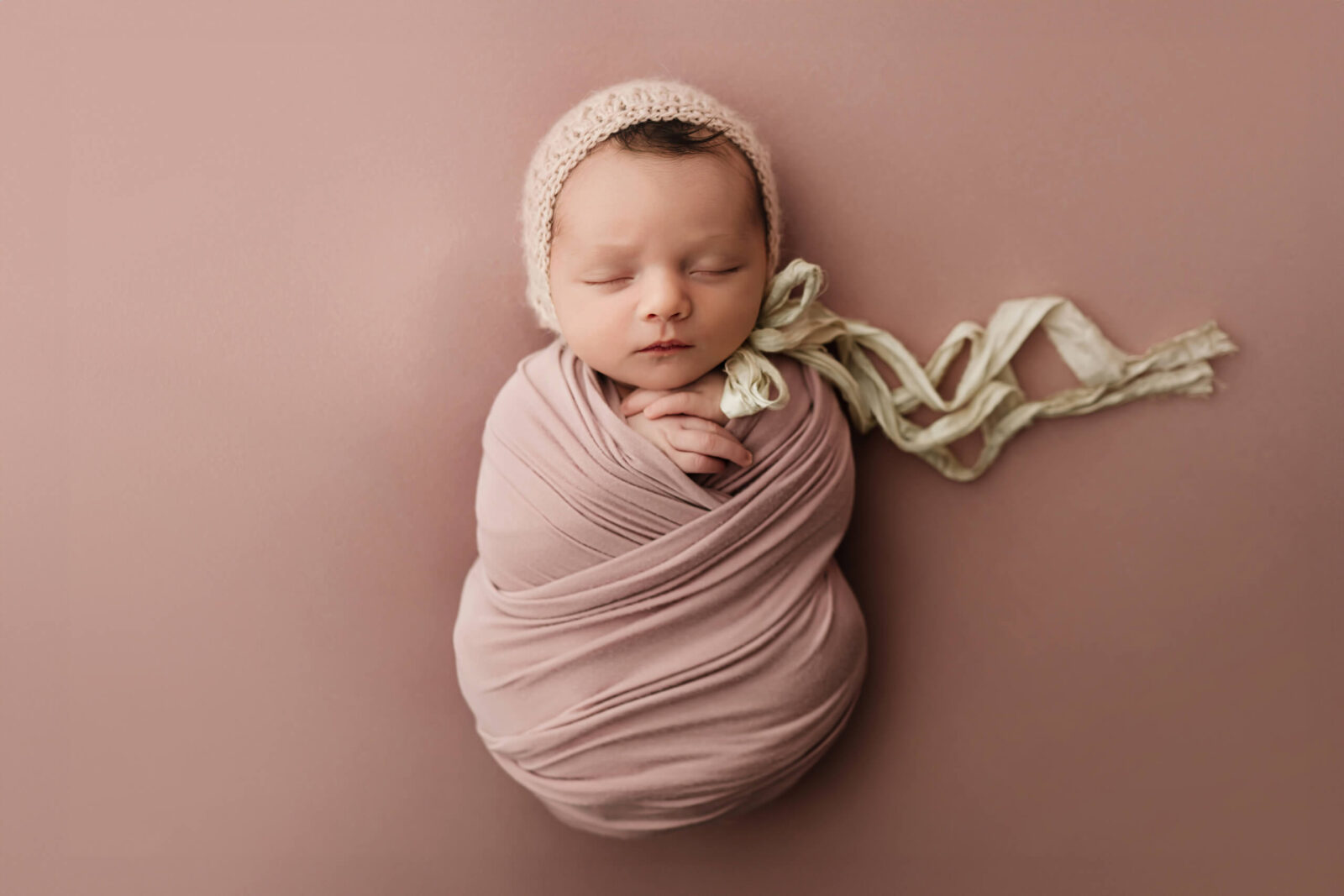 Sleeping newborn wrapped in soft fabric during a simple studio newborn photo session