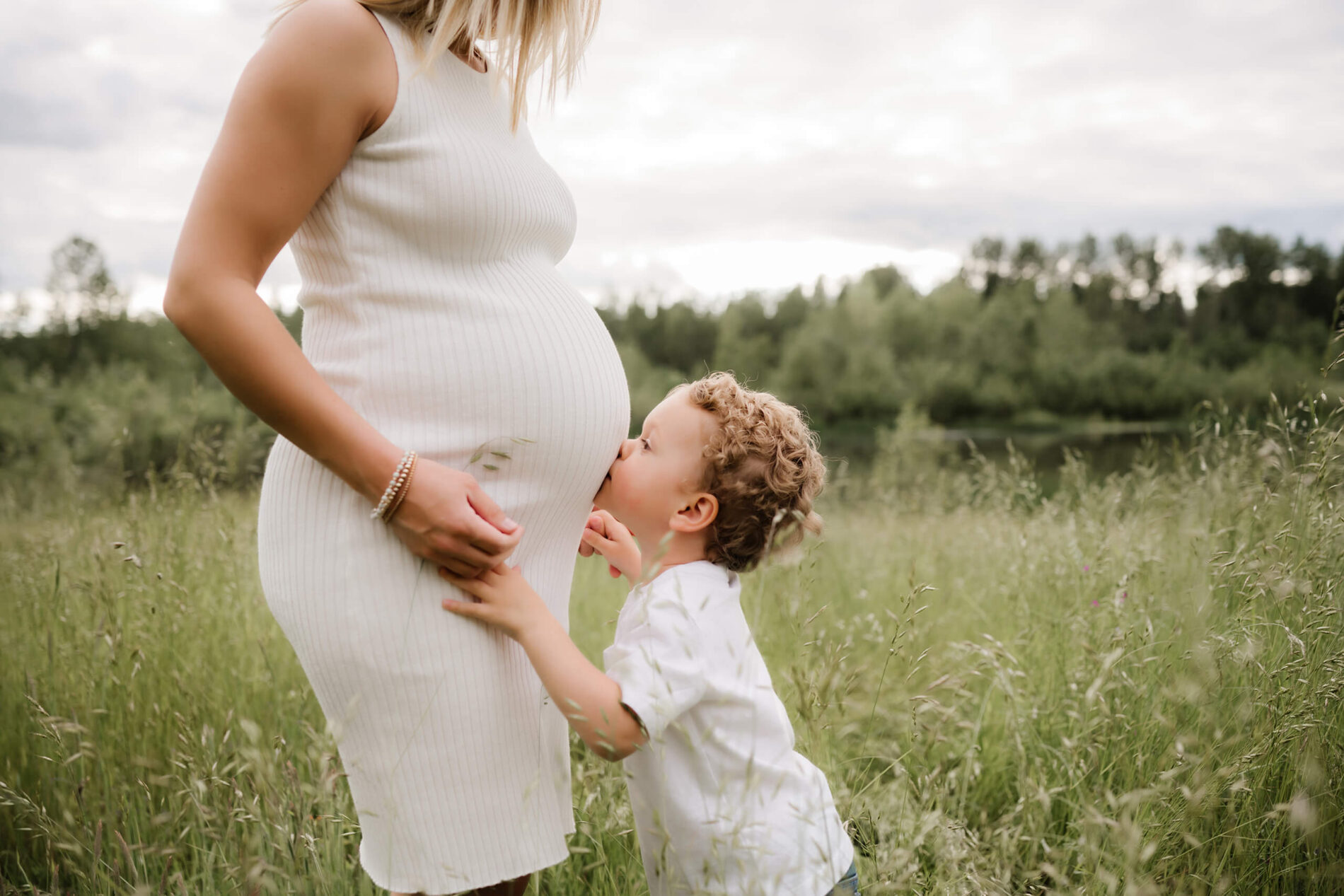 Redmond maternity photographer, pregnant woman with a toddler kissing her belly