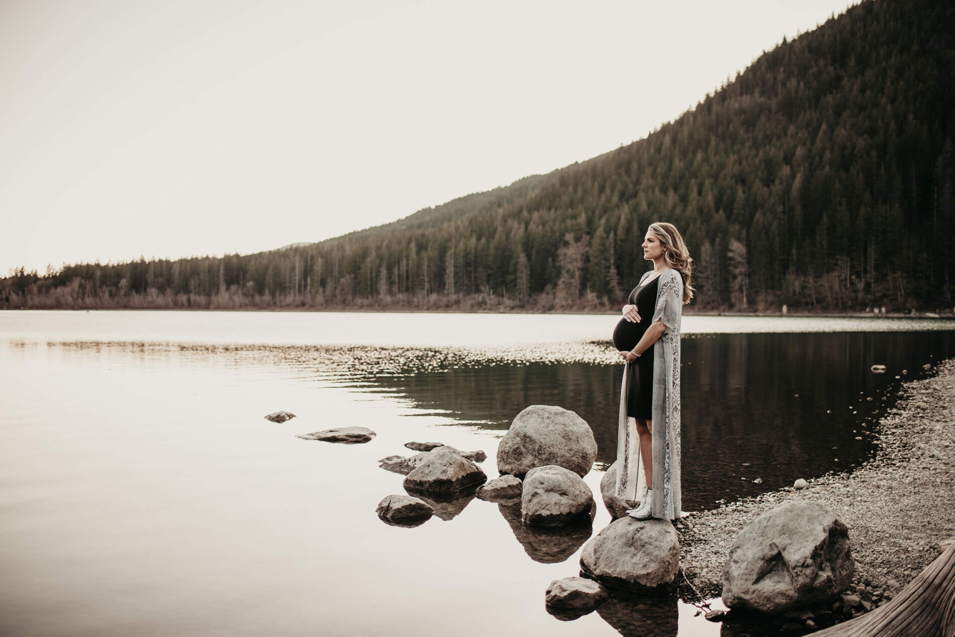 Pregnant woman posed in front of a lake with mountain views during a photos shoot in Seattle