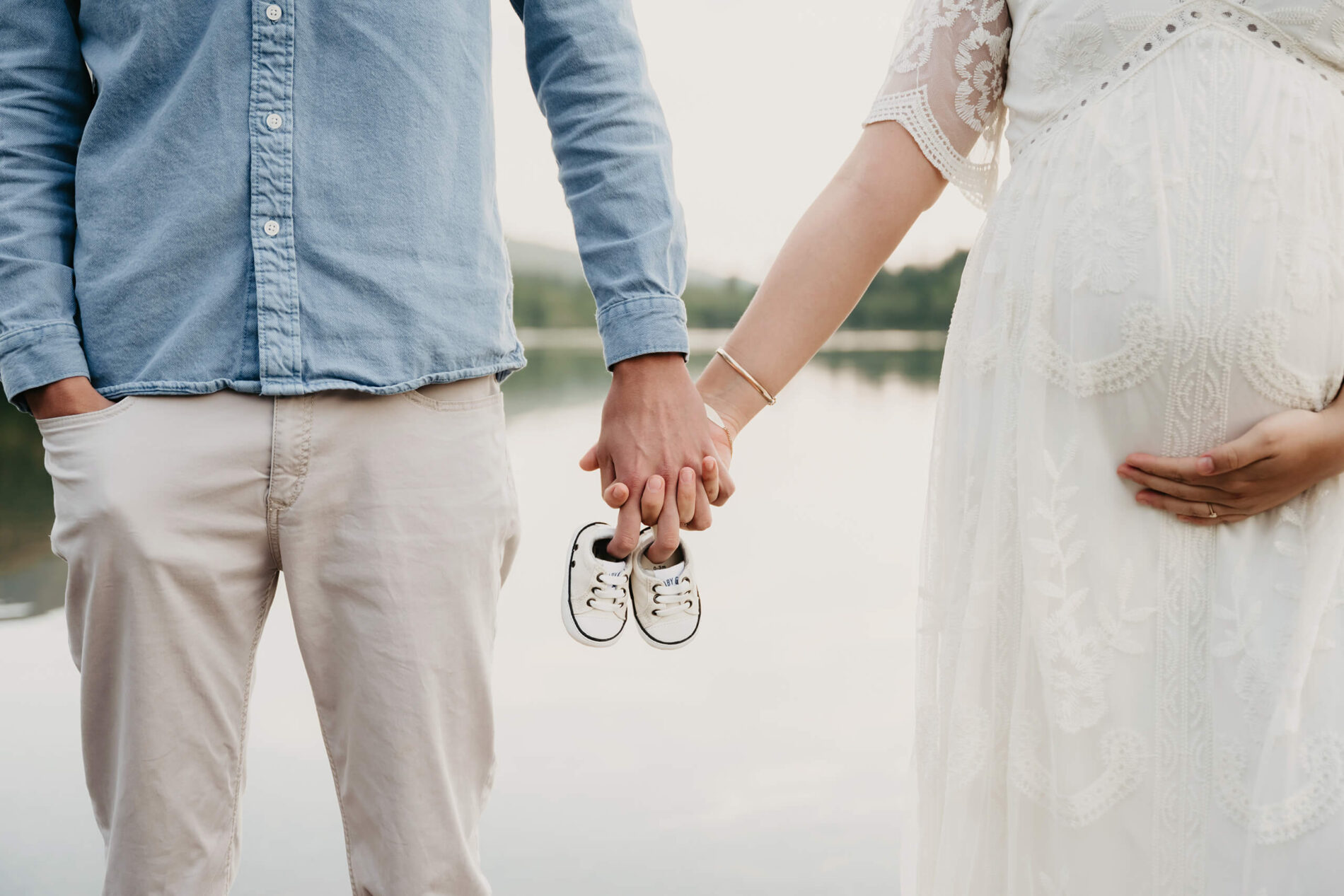 A couple during maternity photo shoot in Seattle, holding tiny baby shoes