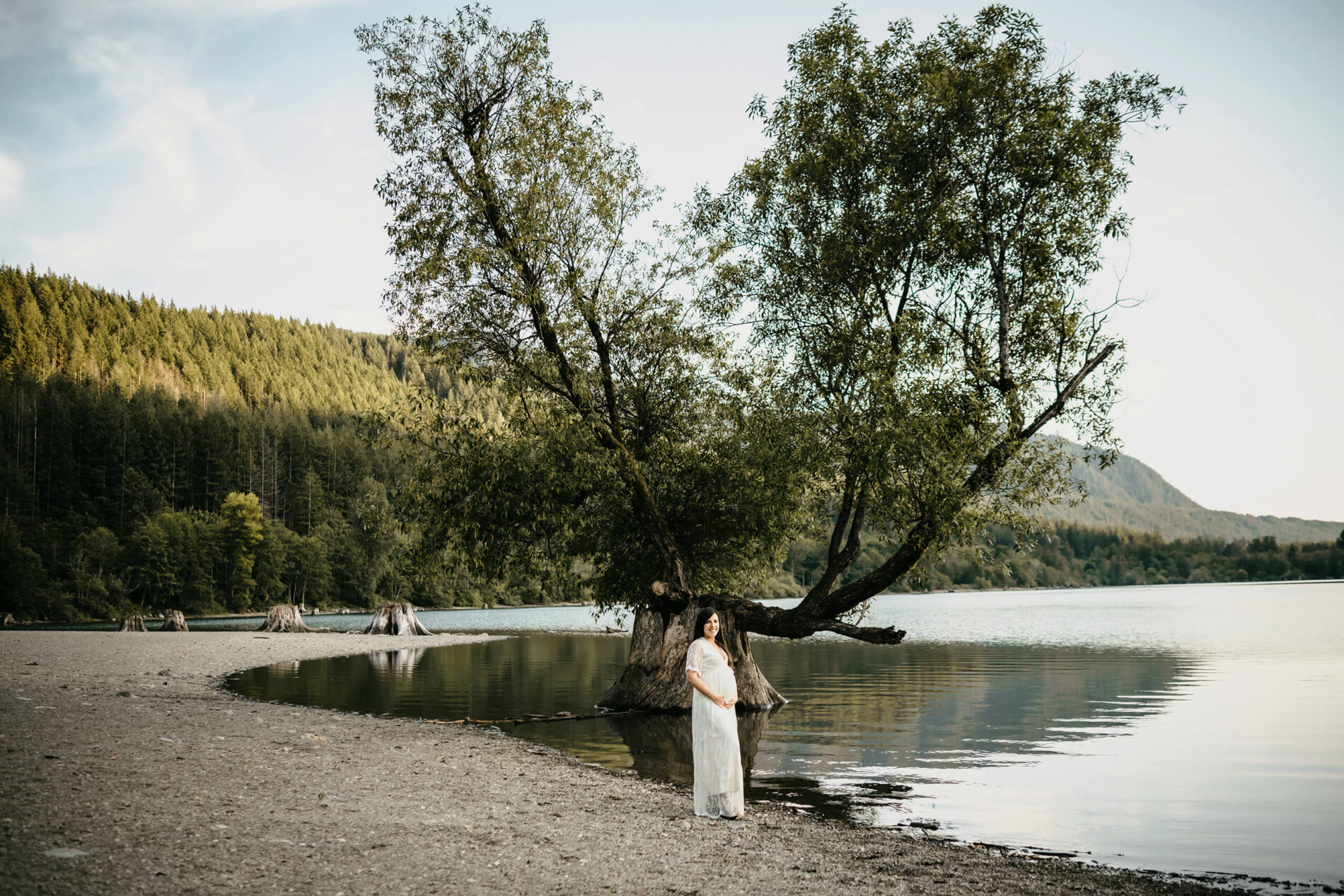 A pregnant woman posing on a beach during maternity photo shoot in Seattle