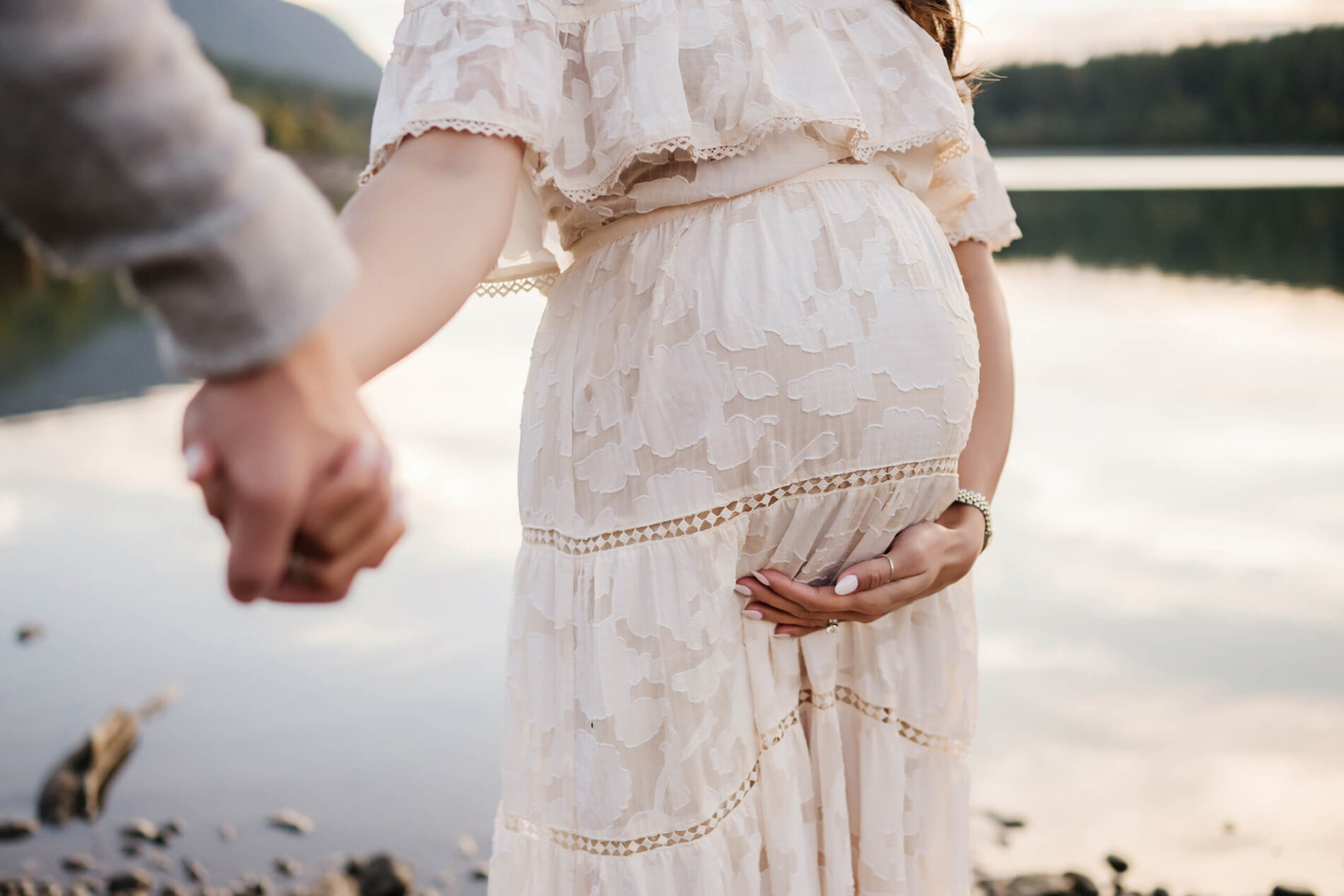 A couple during maternity photo shoot in Seattle, focus on woman's pregnant stomach
