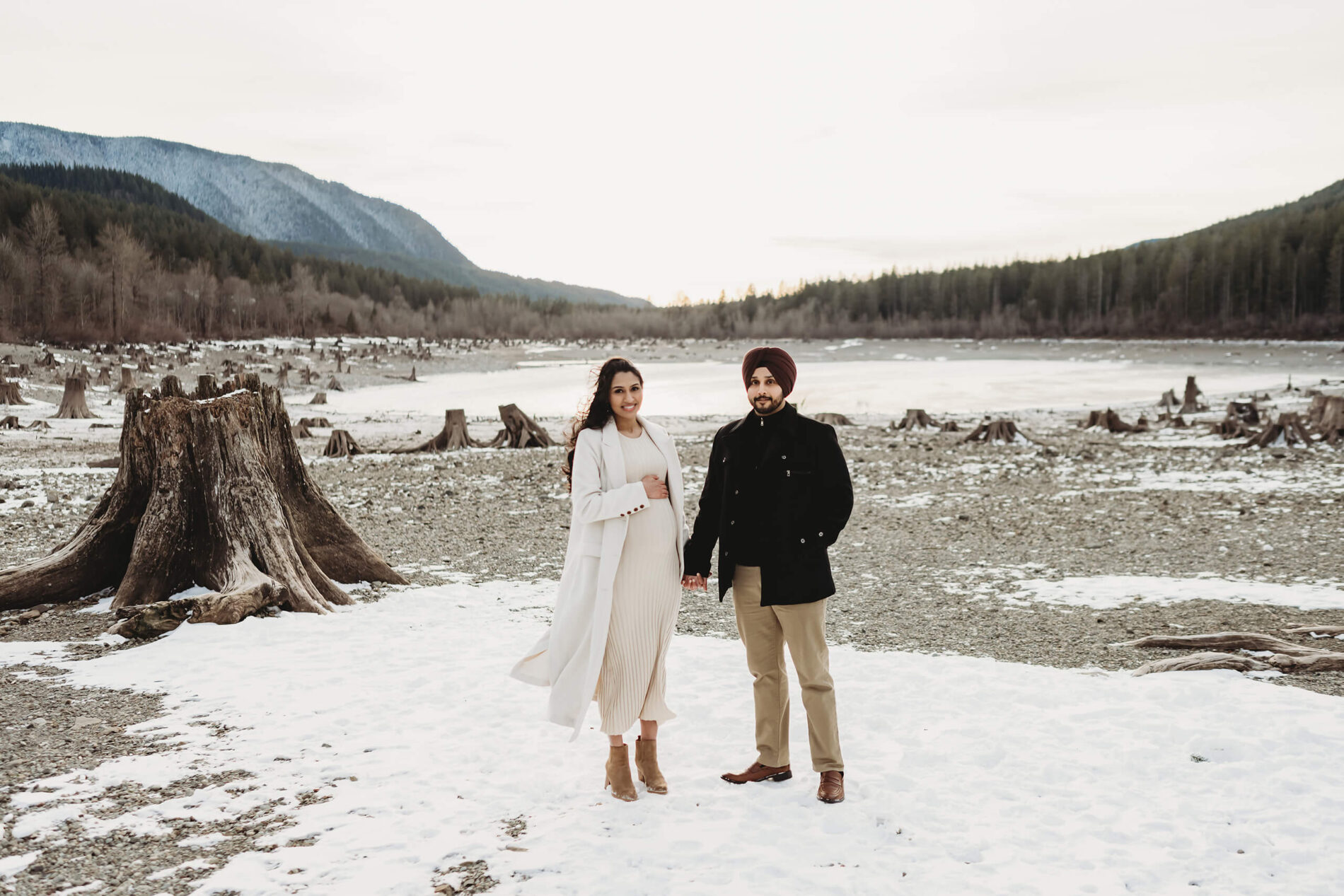 A couple holding hands, posed during maternity session at Rattlesnake Lake in North Bend, WA