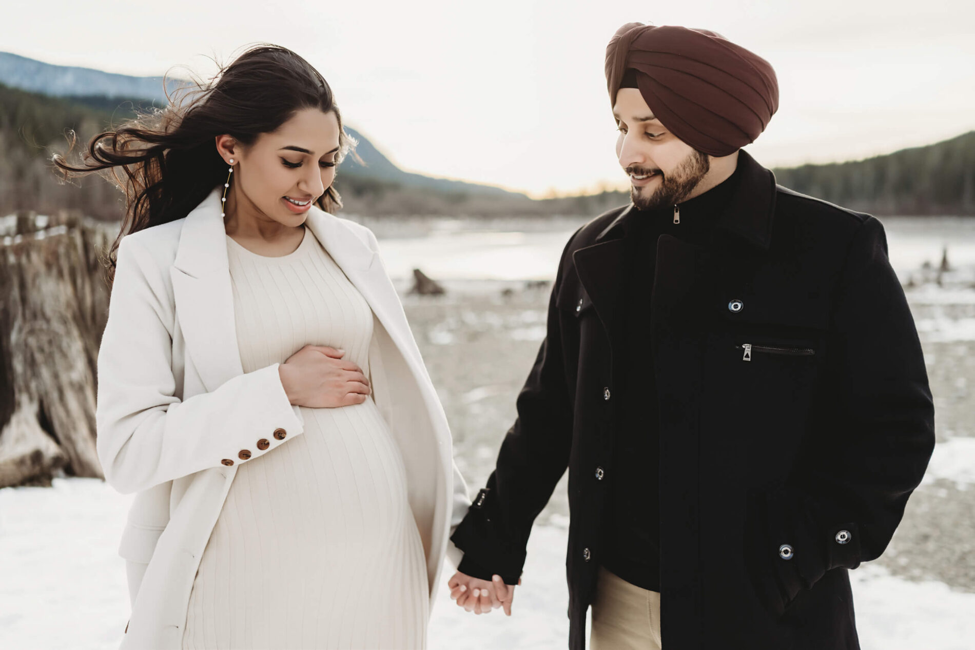 Outdoor lifestyle maternity photo session in Seattle, couple holding hands looking at the belly