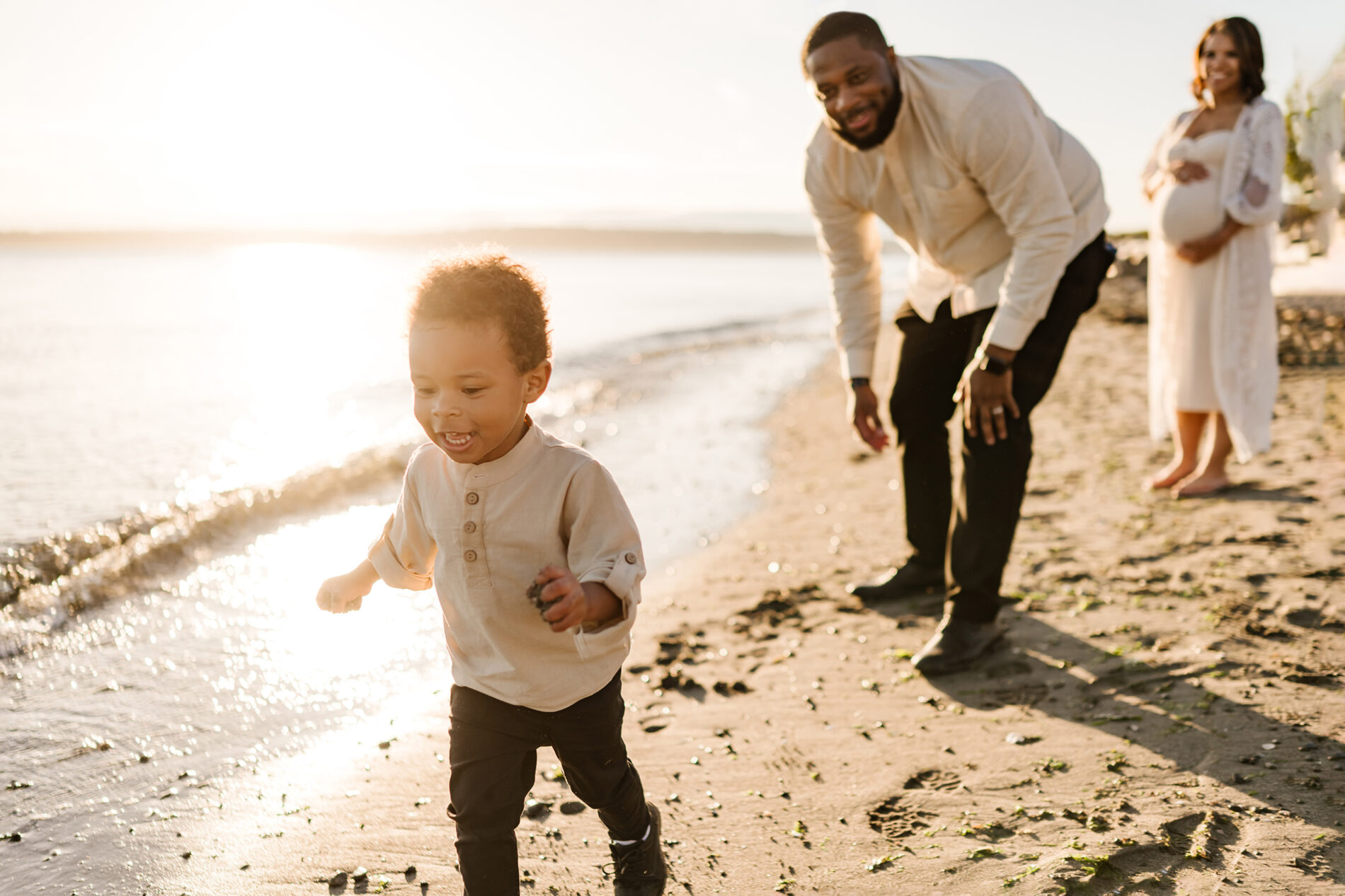 Seattle beach family photo shoot, dad playing with his son with mom looking on