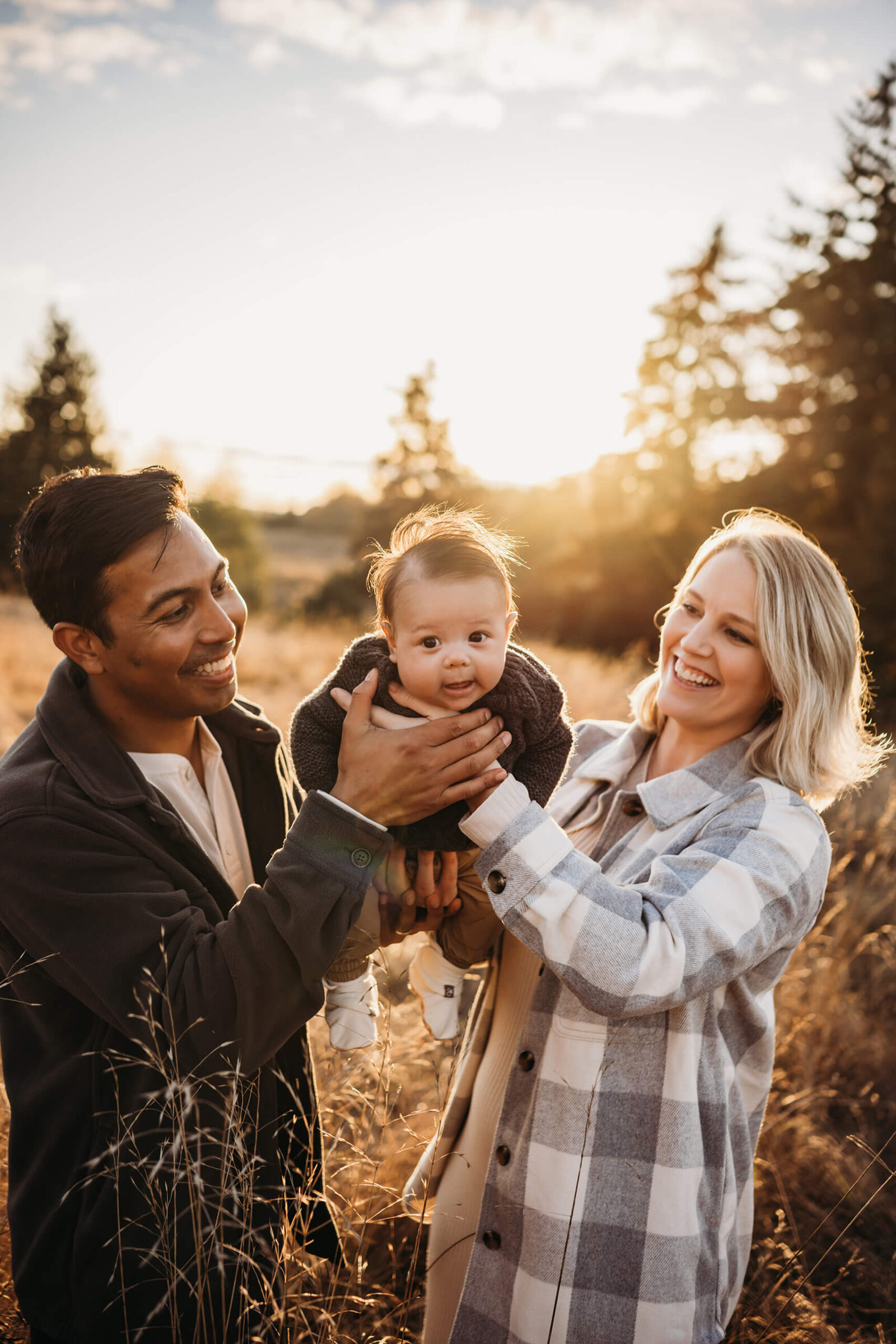 Family photo shoot with a toddler at Seattle Discovery Park, mom and dad playing with their son