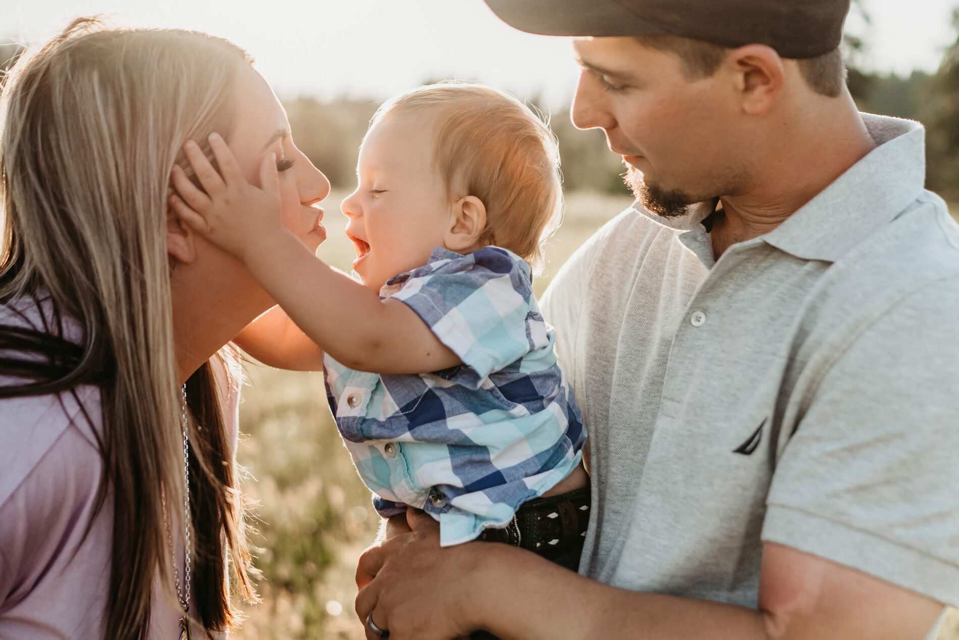 Seattle family photo shoot, dad holding toddler son who is kissing mom
