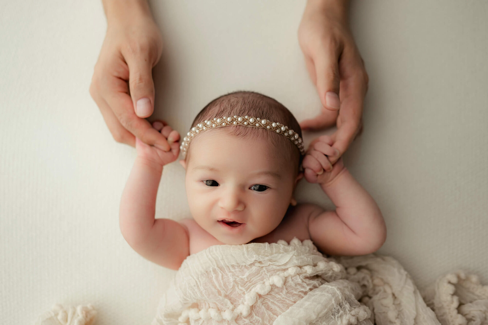 Infant photography idea. A newborn girl squeezing dad's fingers.