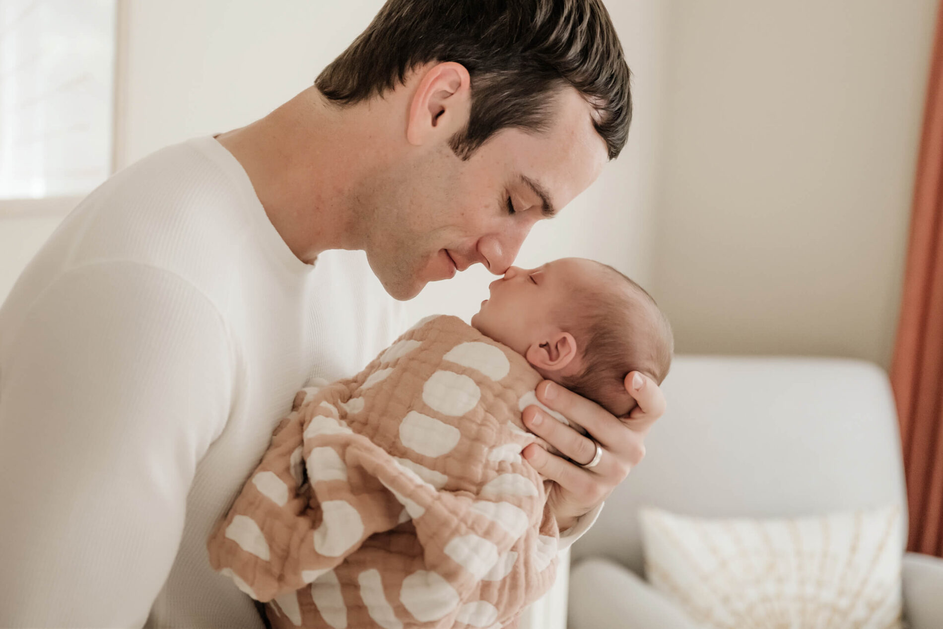 Kirkland lifestyle newborn photography. Dad holding his newborn girl, their noses touching.