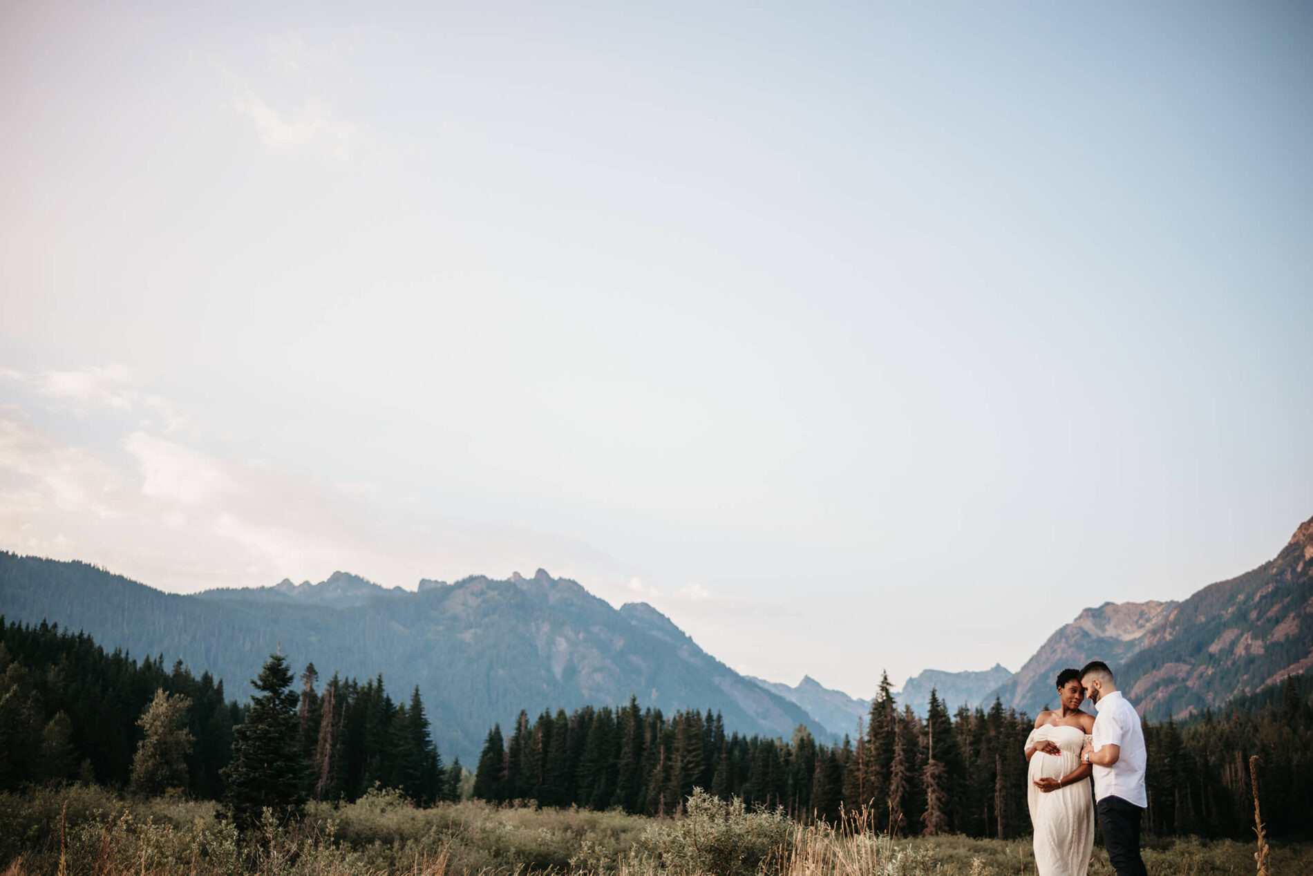Maternity photoshoot on a mountain in Seattle, young couple posing for pregnancy photo