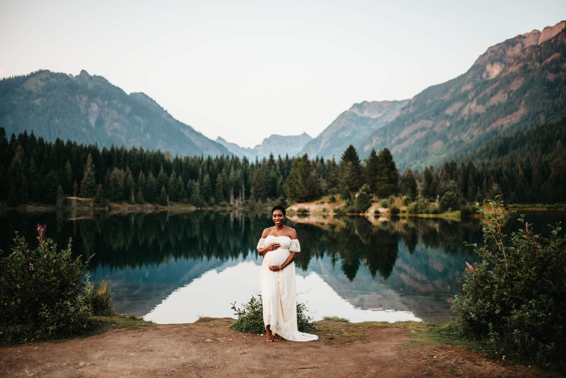 Seattle maternity photography with mountain backdrop, young woman in a white dress posed for a pregnancy photo