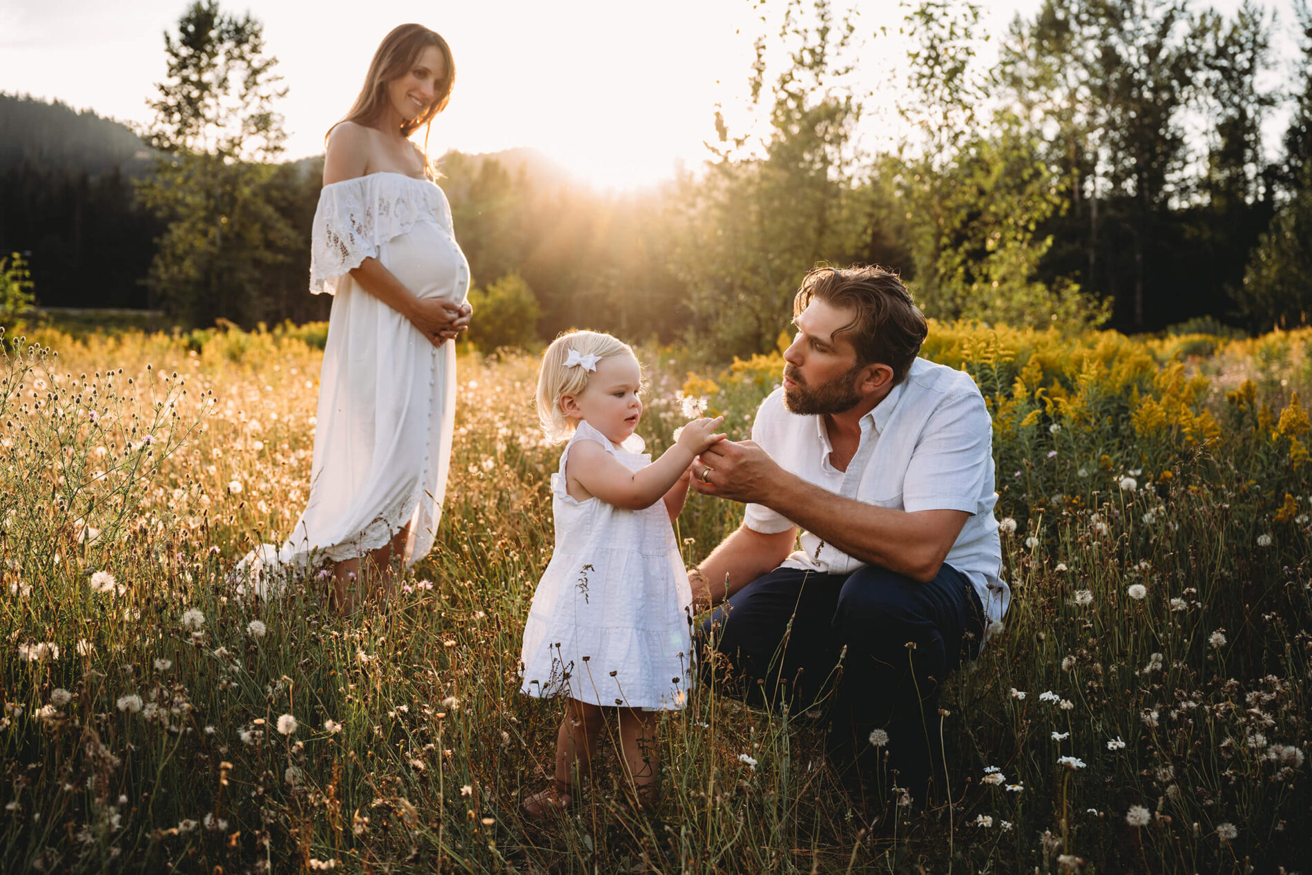 Natural posing idea for maternity photo with a toddler in Seattle, family in a field of wildflowers