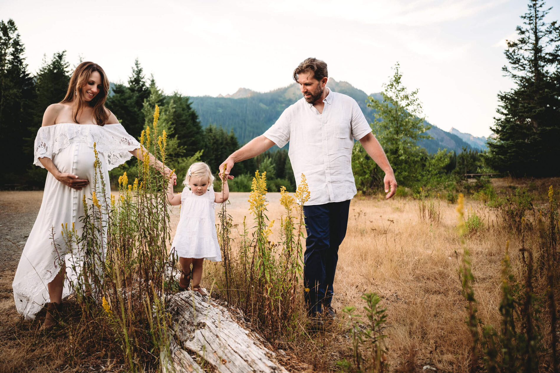 Natural posing idea for maternity photo with a toddler in Seattle, mountains in the background