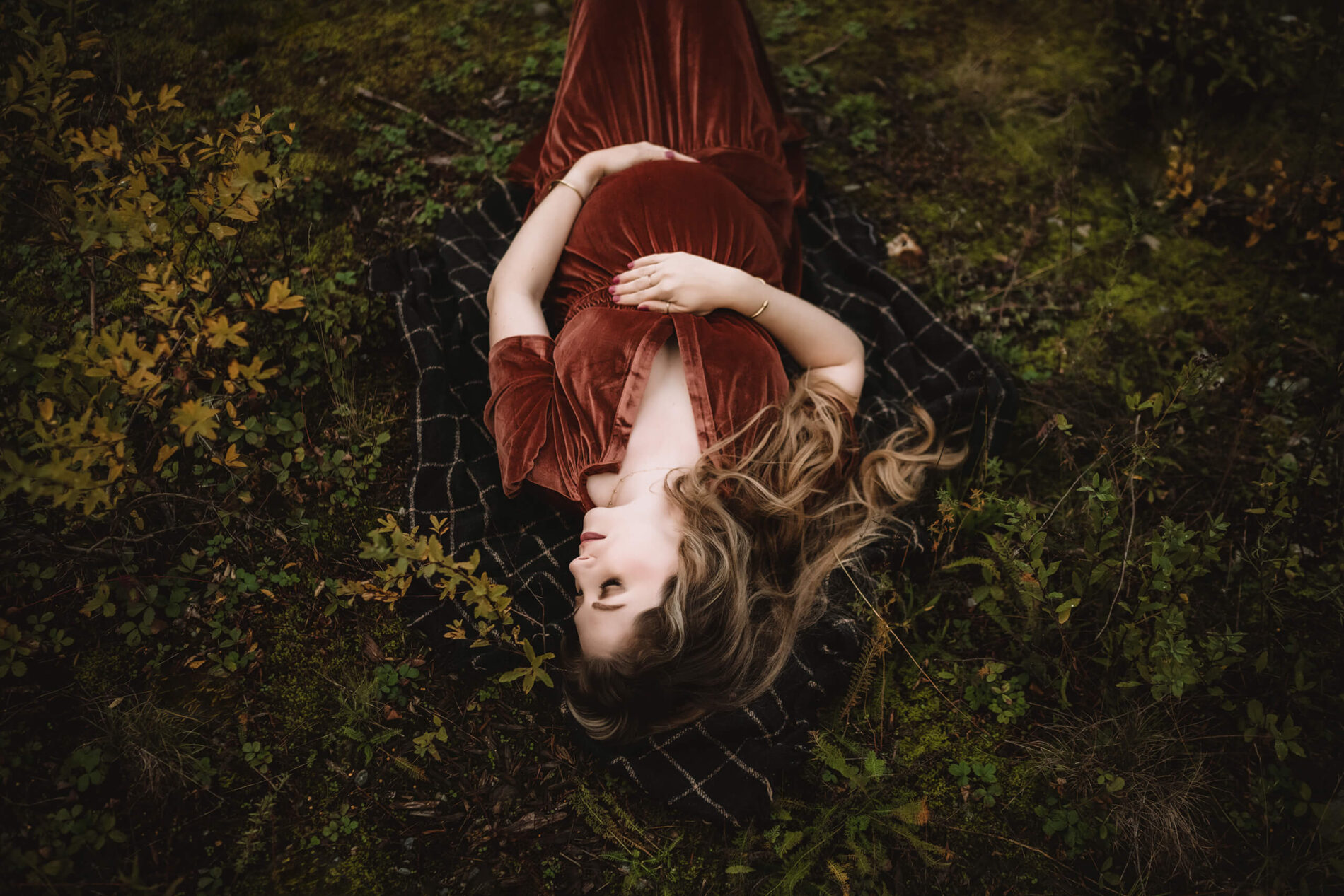 Unique posing idea for maternity photo in Seattle, pregnant woman lying in a field