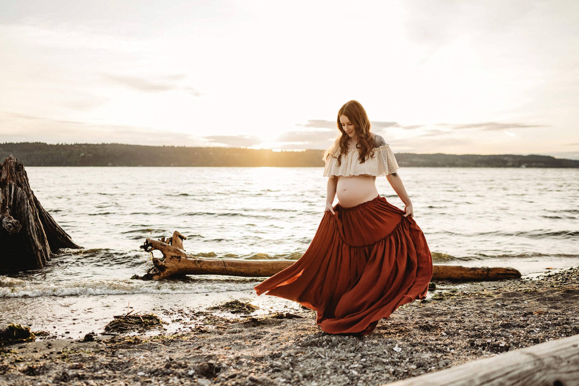 Seattle beach maternity session, young pregnant woman walking on a beach during sunset