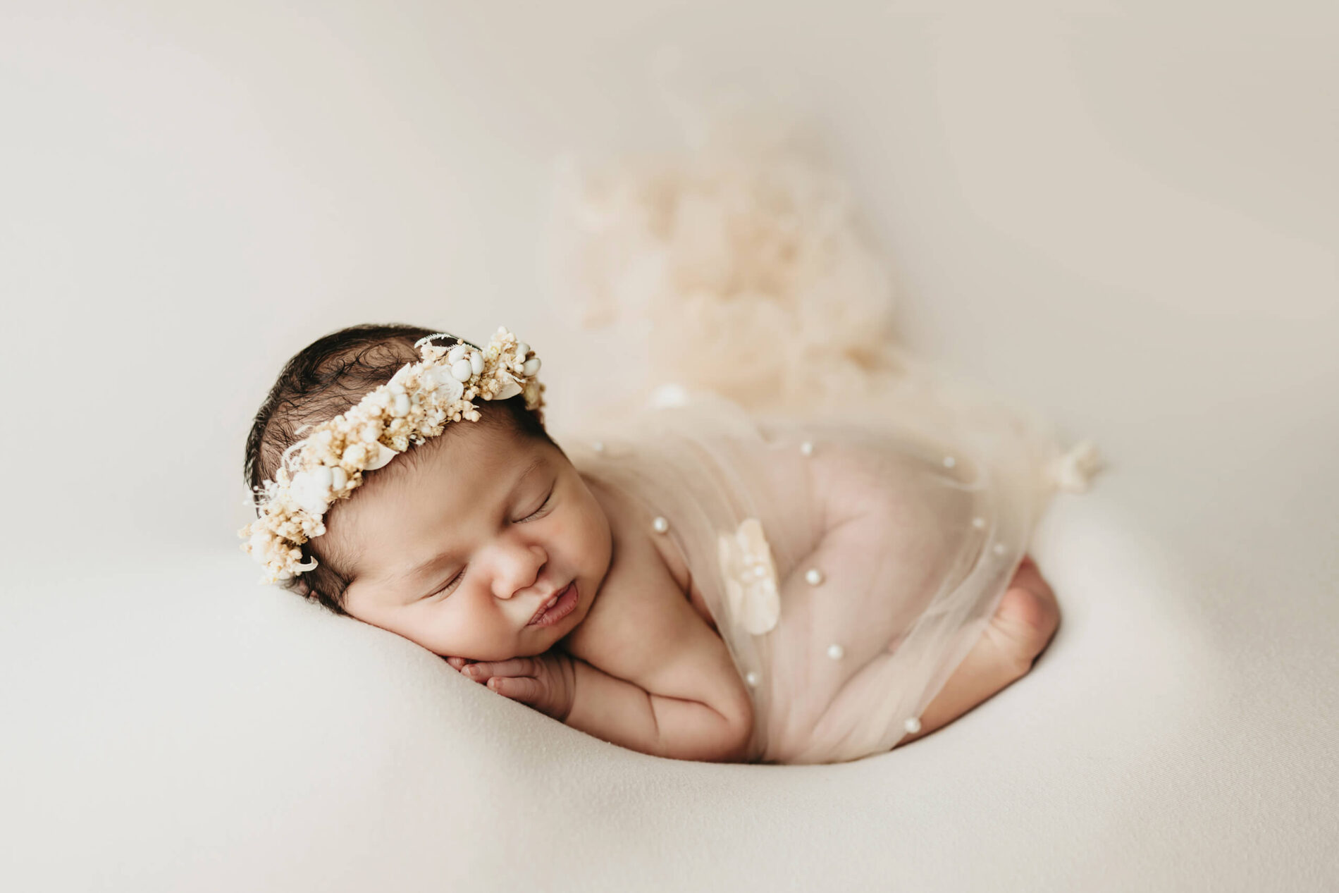 Elegant newborn photography in a Seattle. Sleeping baby girl wearing an elegant headband.