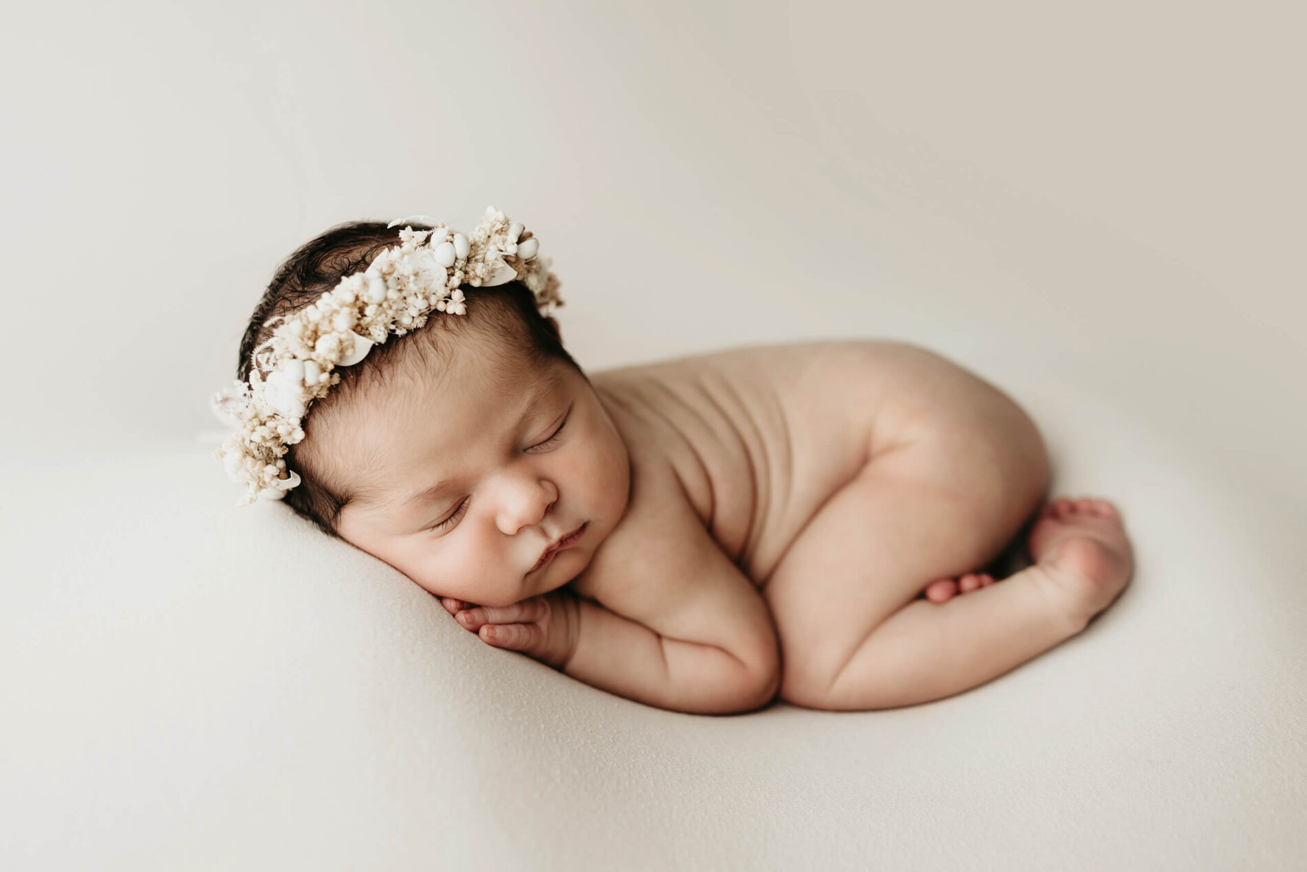 Timeless newborn photography in Seattle. Beautifully posed baby girl wearing an elegant headband.