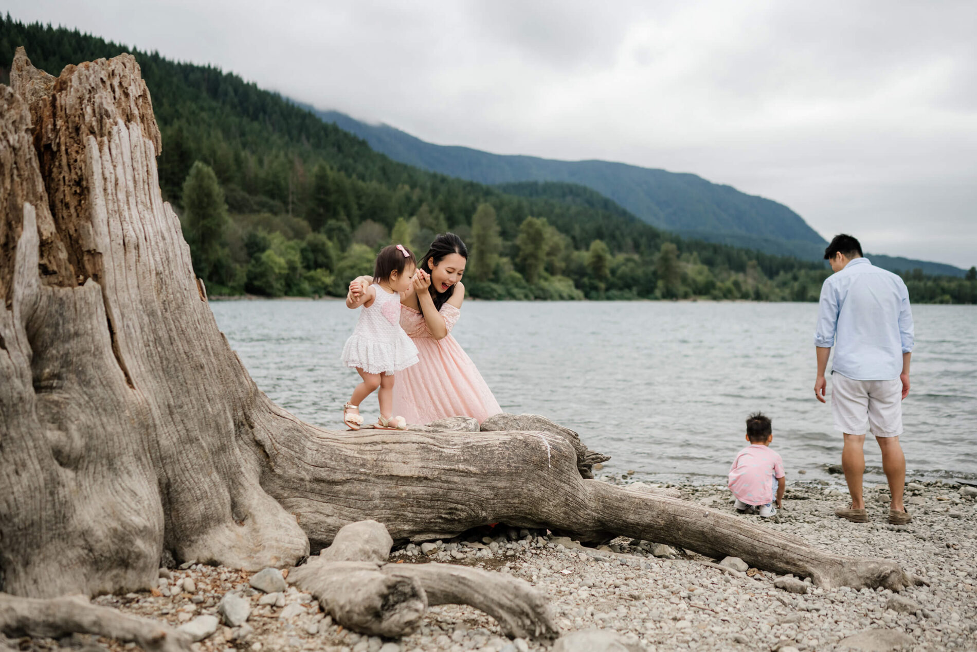 An easy going family photo shoot at Rattlesnake Lake. Mom is playing with her daughter while dad is skipping rocks their son. Beautiful lake and mountain views.