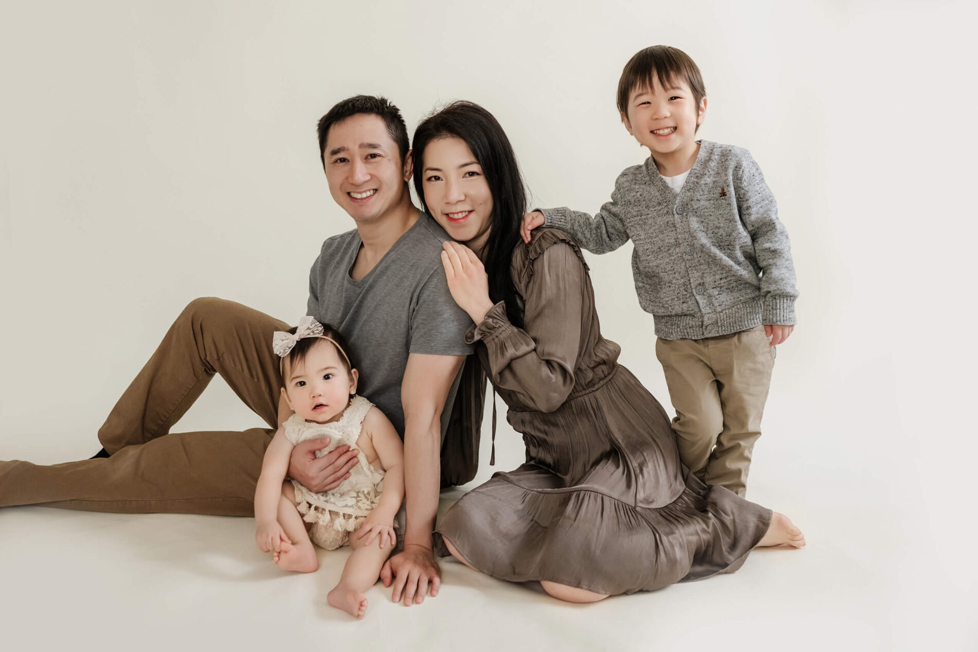 Family posing during a milestone photo session in a Seattle studio