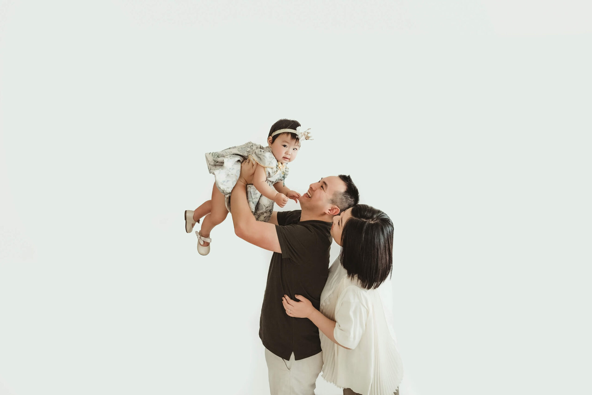 Parents playing with their daughter during studio 1st birthday photoshoot