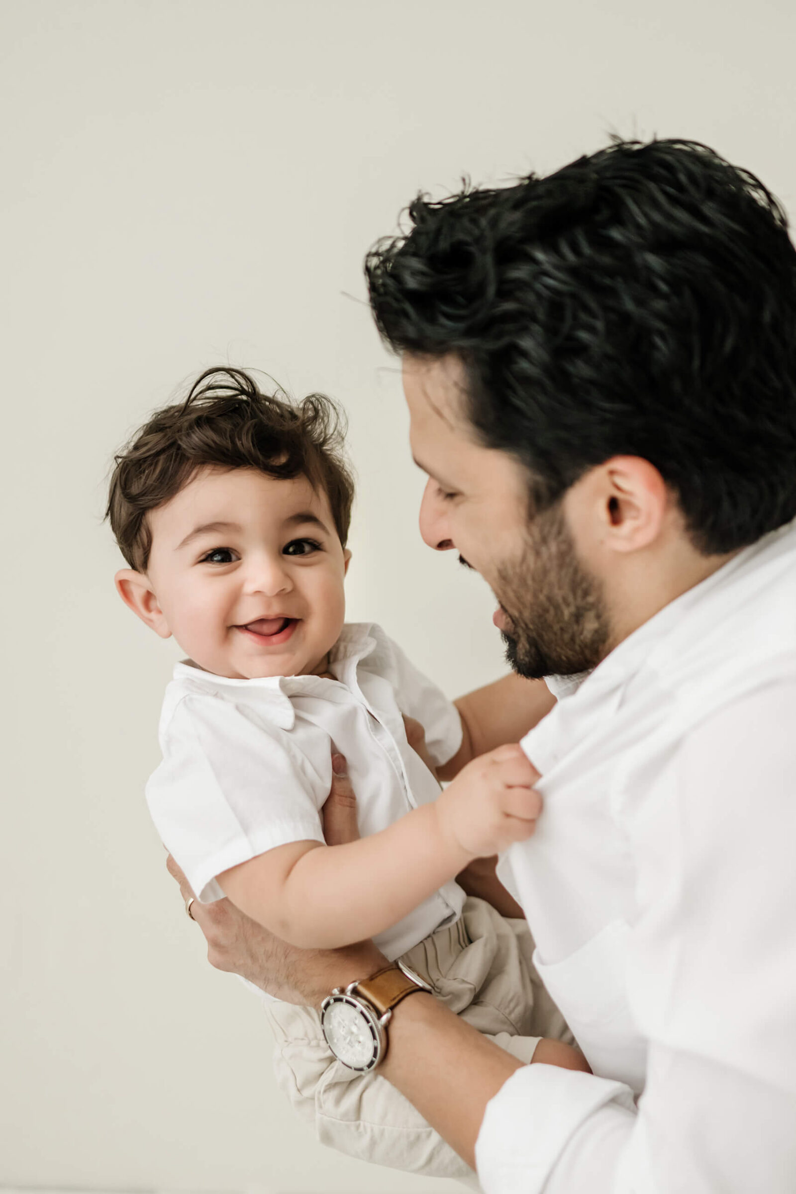 Father holding his smiling baby during a simple studio milestone session