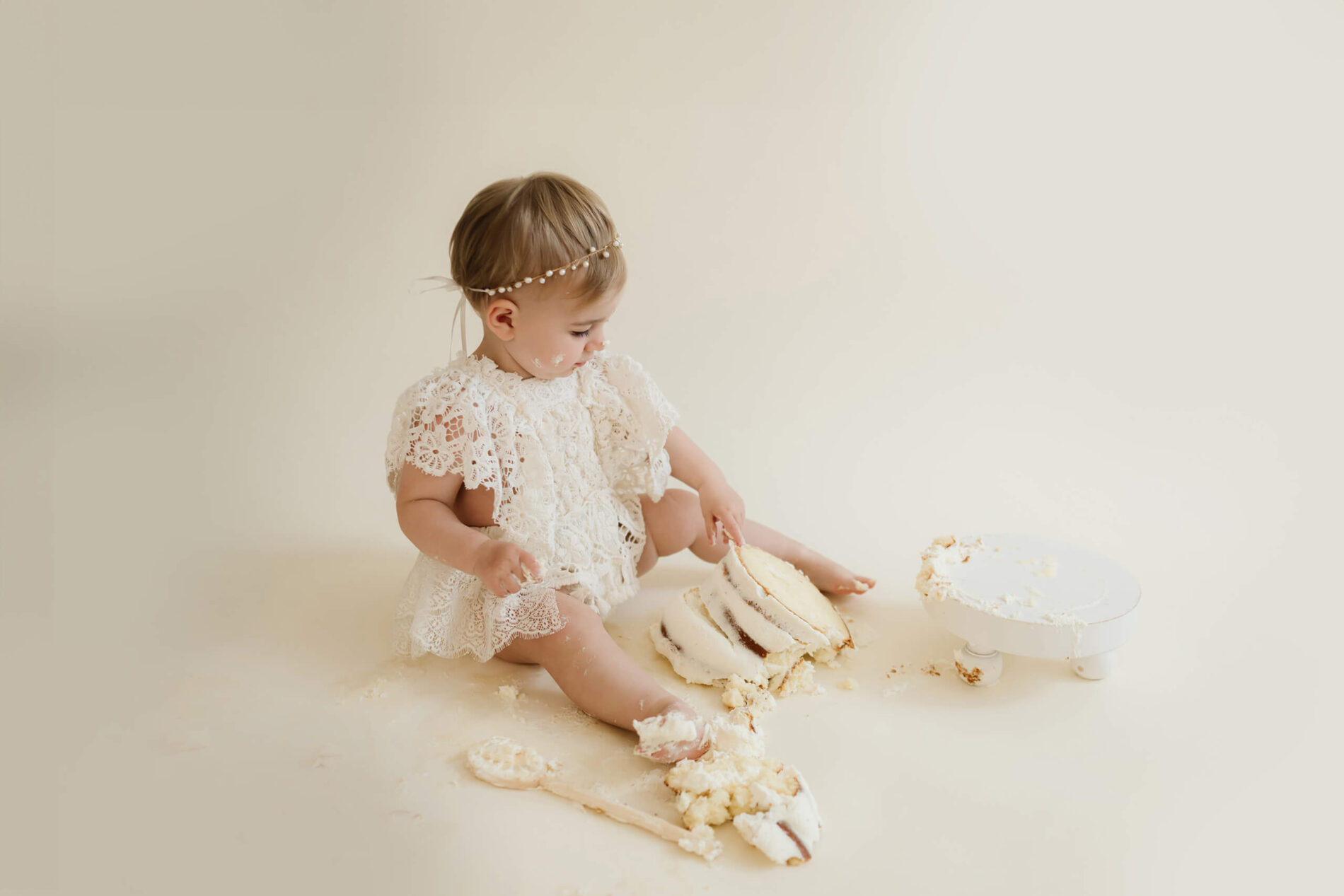 A girl eating cake during cake smash photo session in Seattle studio