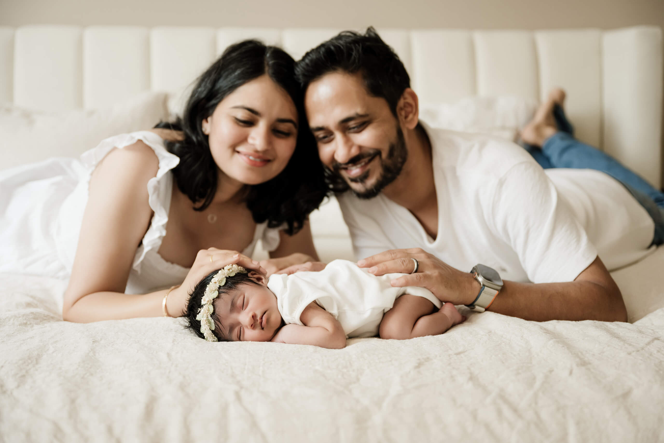 Parents cuddling with their daughter during newborn in-home lifestyle photoshoot in Seattle