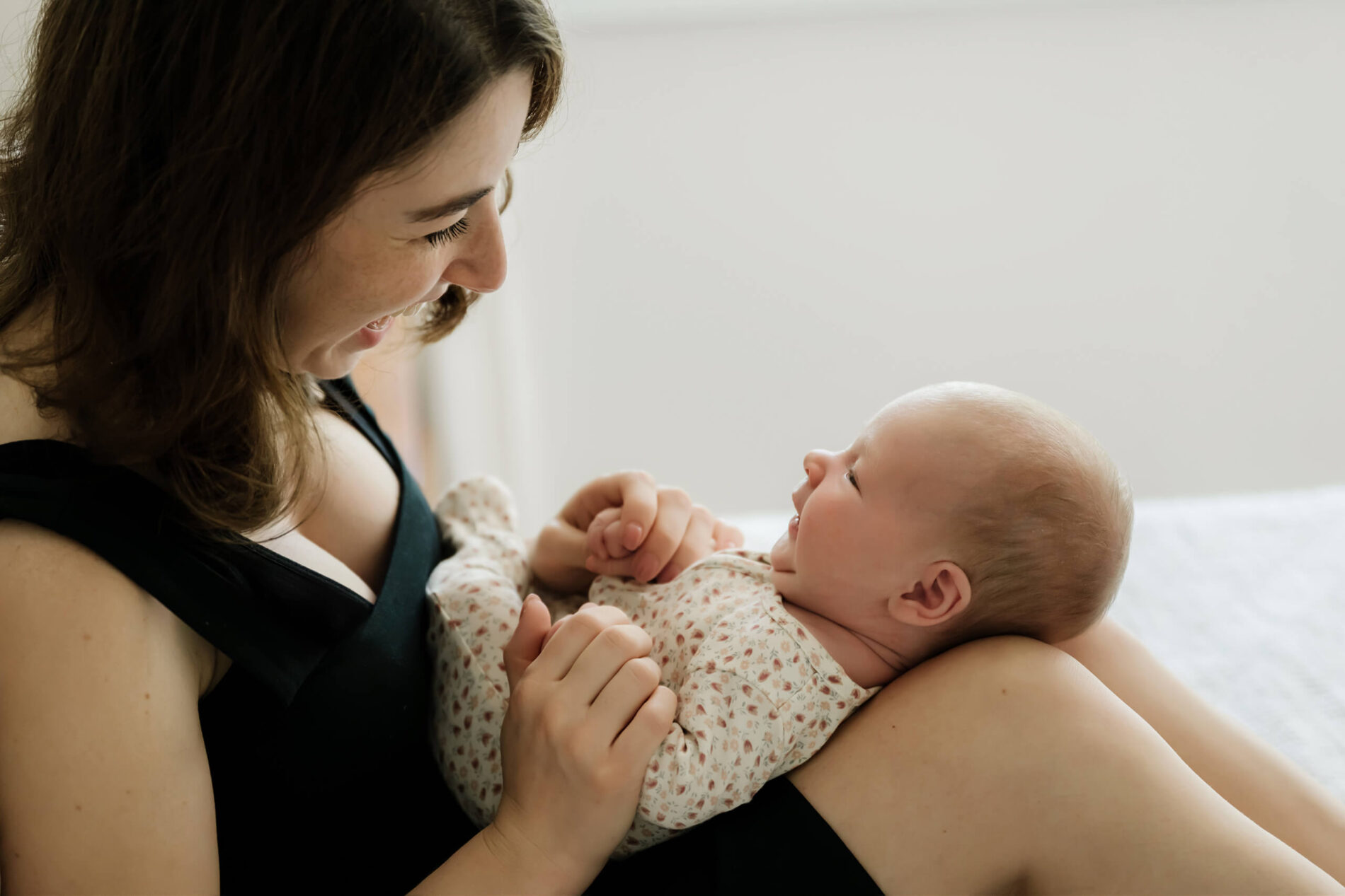 Mom smiling at her son during Seattle newborn in-home photoshoot