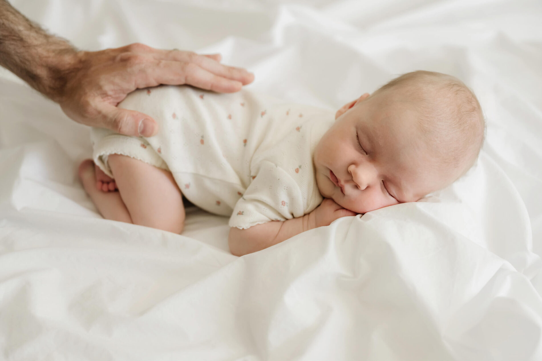 A classic portrait of dad's hand resting on his newborn