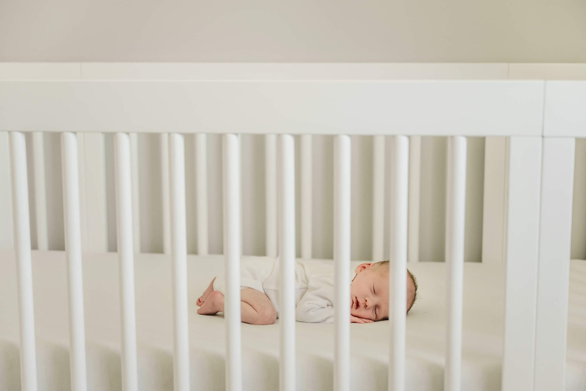Portrait of newborn sleeping in his crib