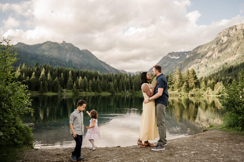 Family standing by a mountain lake during an outdoor family photo session