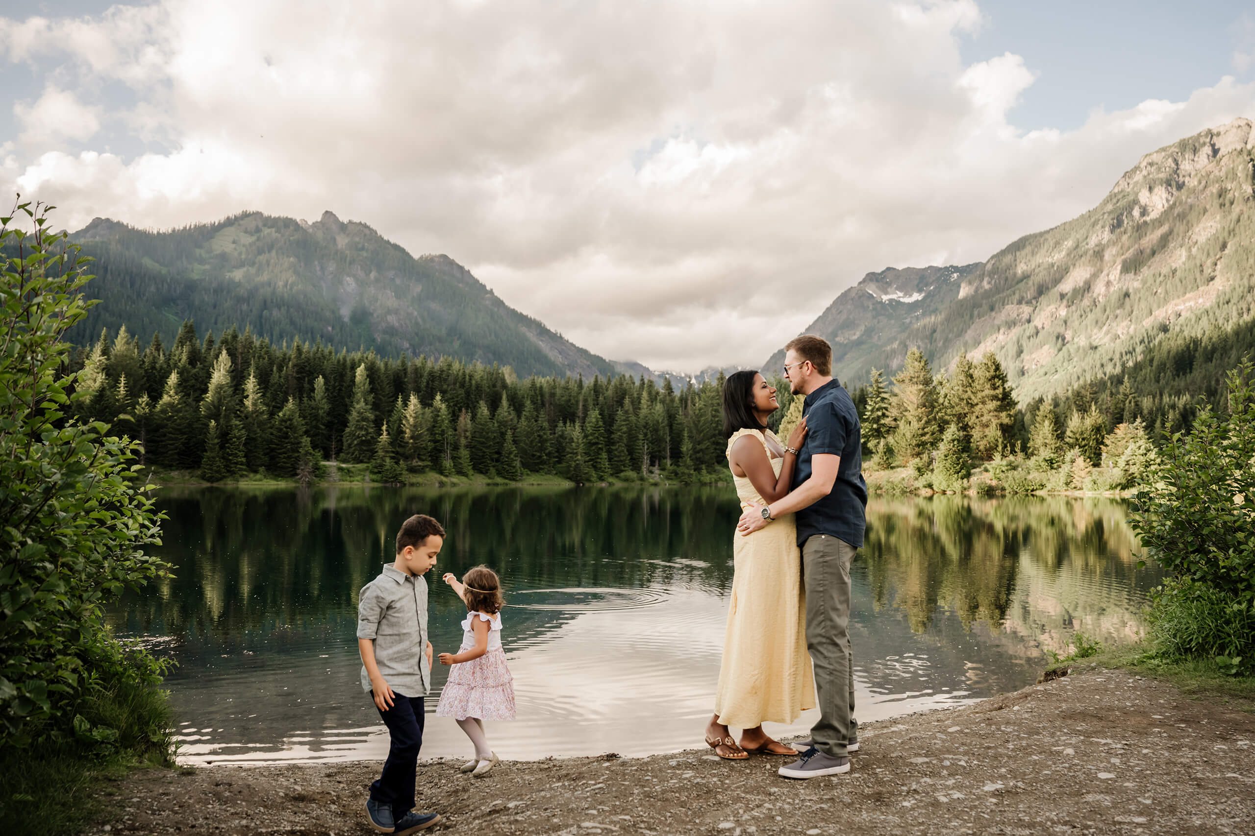 Family standing by a mountain lake during an outdoor family photo session