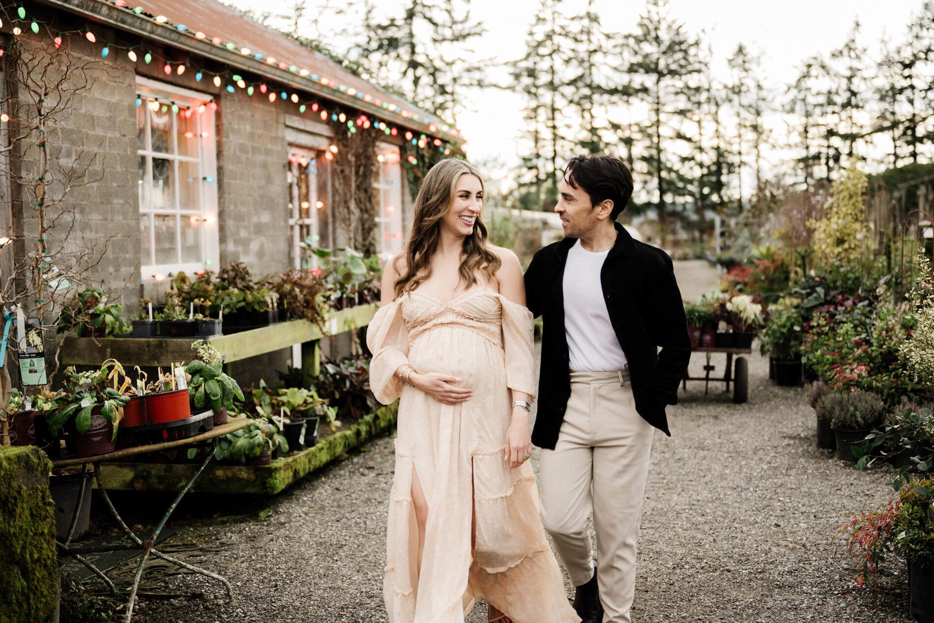 Couple walking in a Seattle nursery during maternity photoshoot