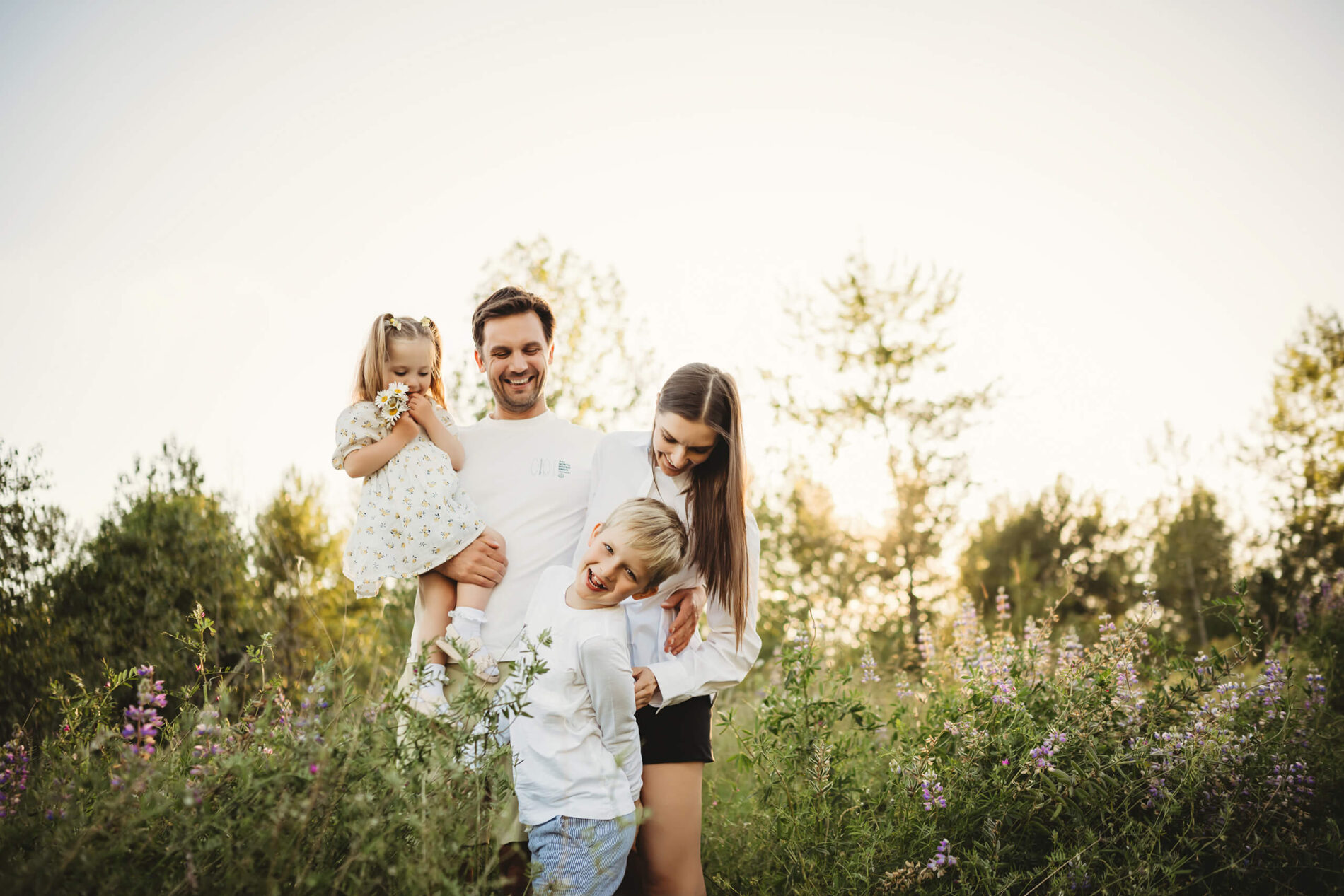 Family of four playing in a field of wildflowers during photoshoot in Seattle