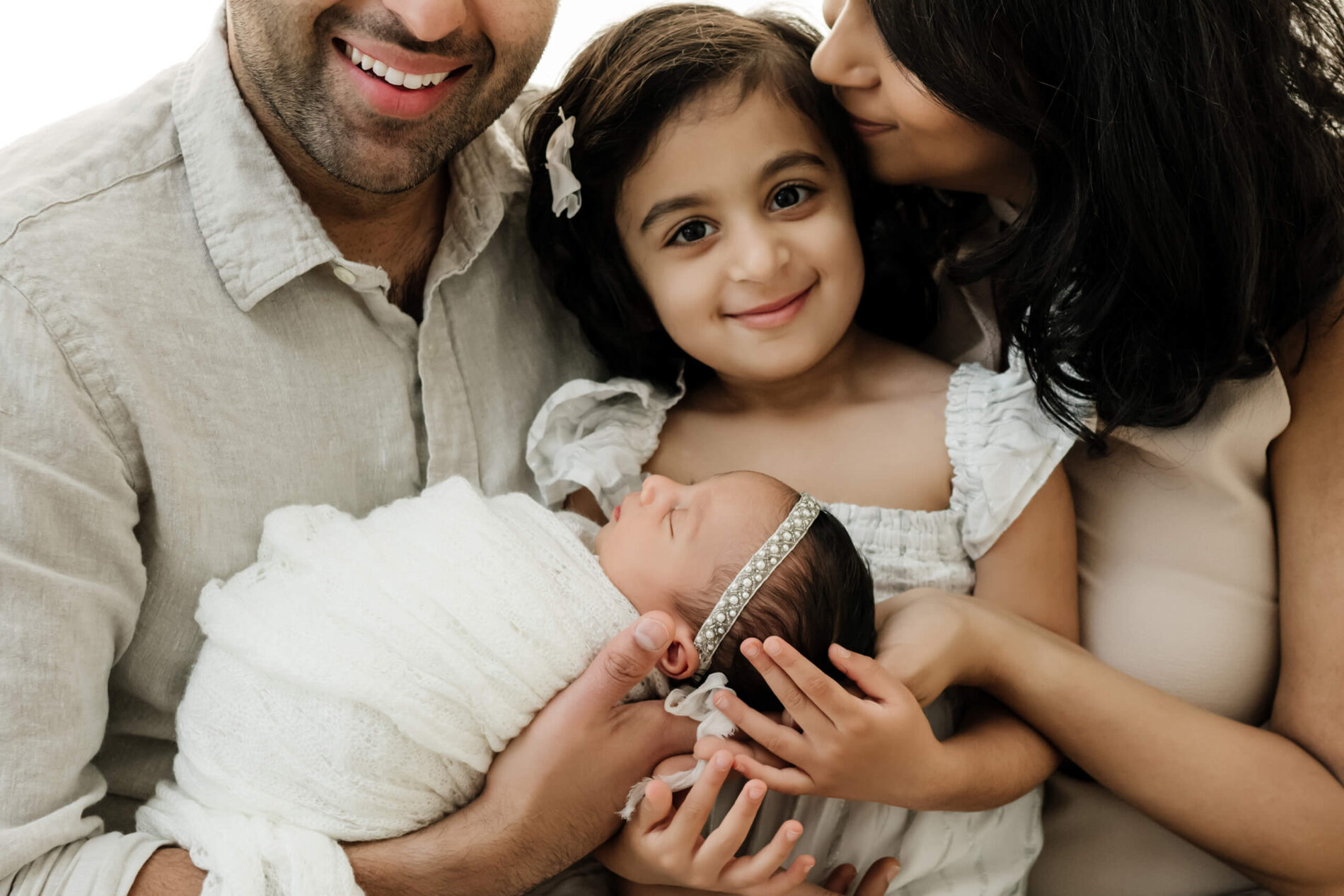 Snugly family posing with newborn in Kirkland studio
